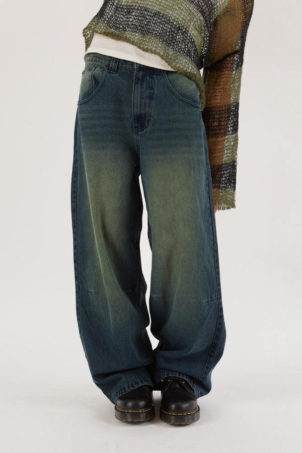 Male wearing Sandblast Oversized Skate Fit Denim Jeans. Styled with green and black knitted jumper. 
