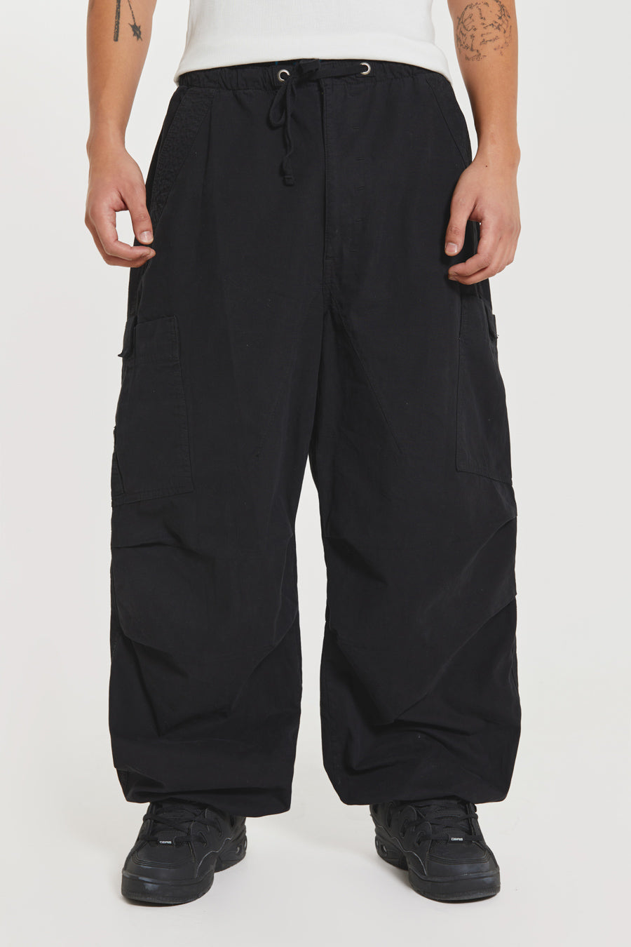 Unisex black oversized fitted parachute style cargo trousers with six pocket styling. 