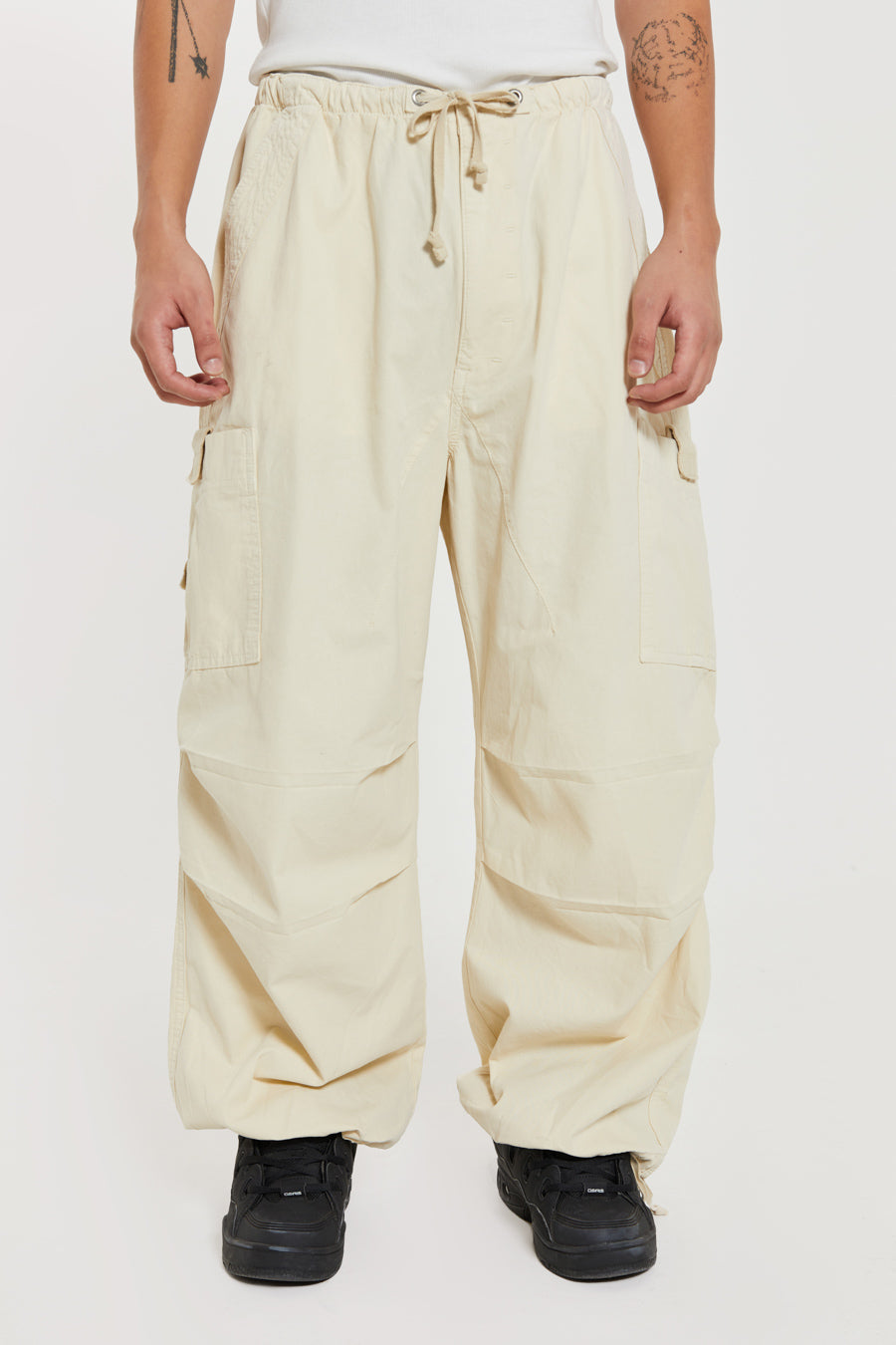 Unisex ecru oversized fitted parachute style cargo trousers with six pocket styling. 