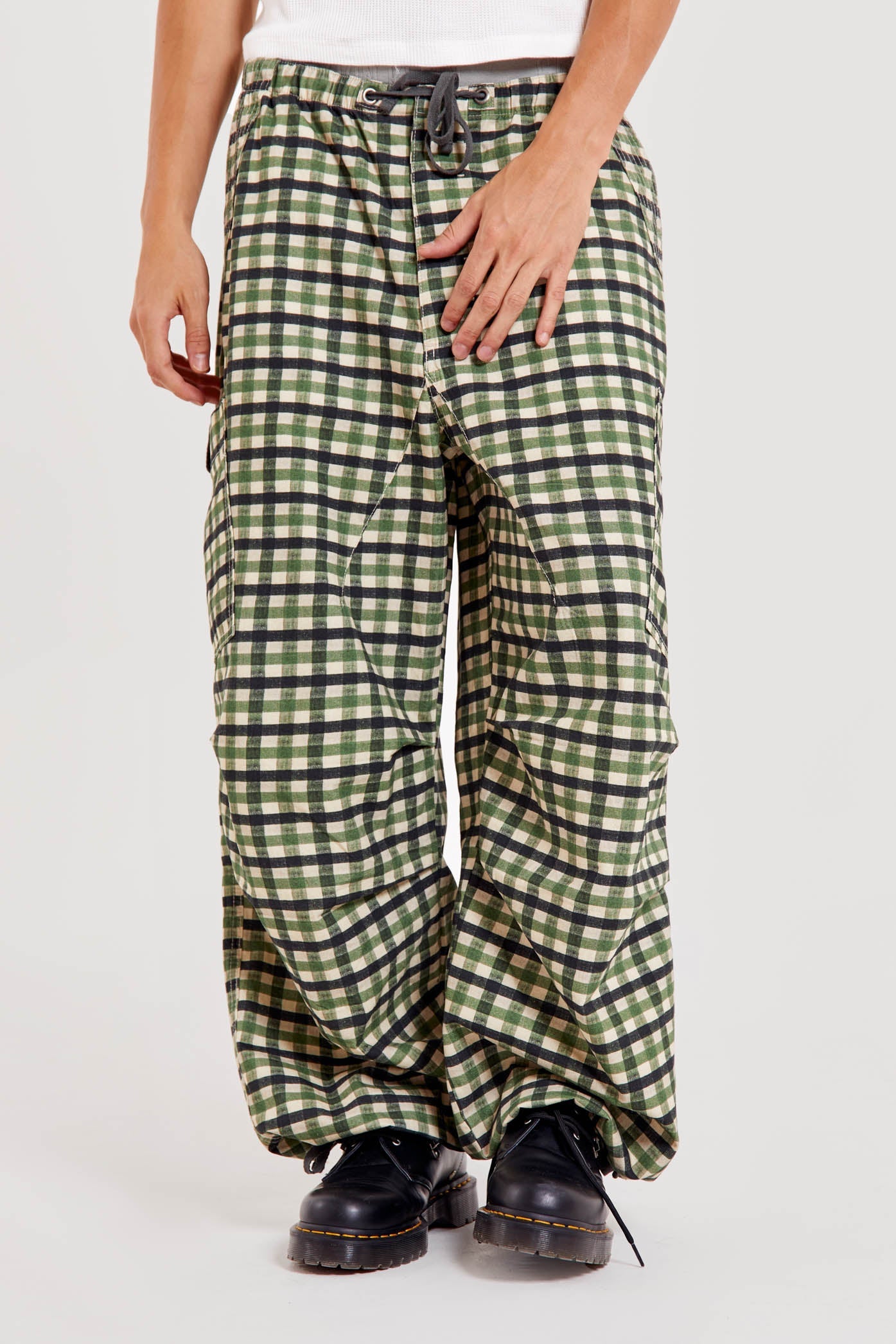 Male wearing green gingham printed check military style oversized cargo pants. 