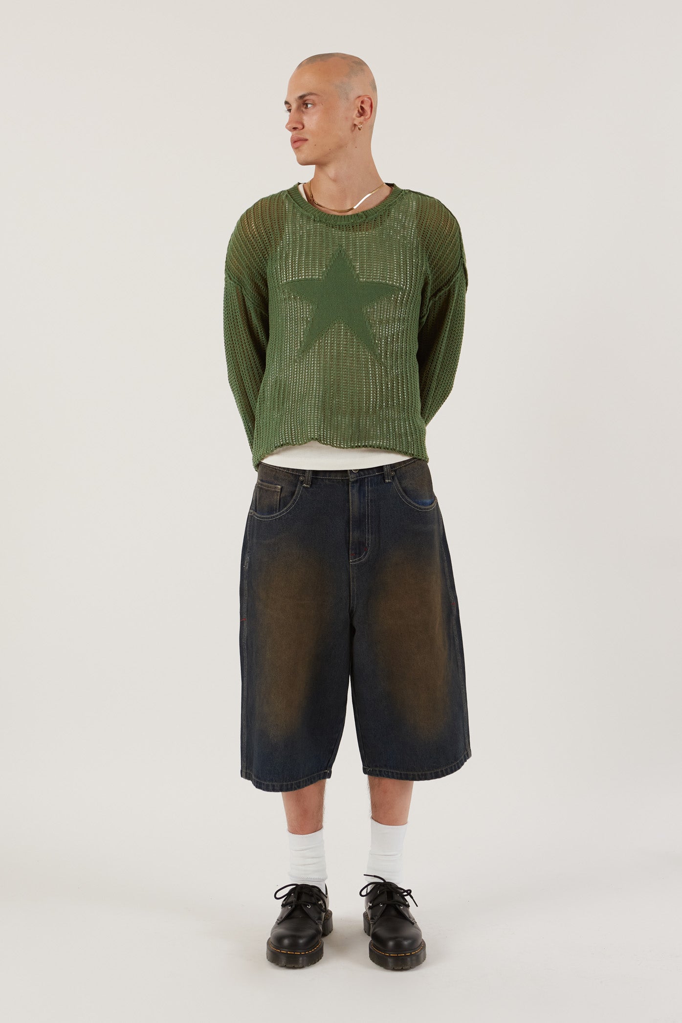 Male wearing Khaki Green Star Loose Knit Jumper.  Styled with blue oversized denim shorts.