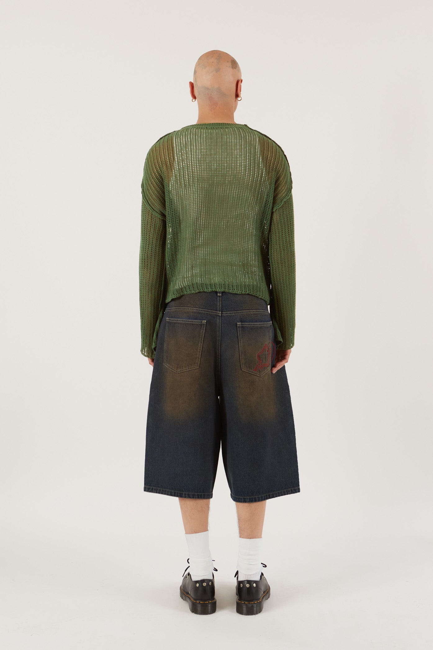 Male wearing Khaki Green Star Loose Knit Jumper.  Styled with blue oversized denim shorts.