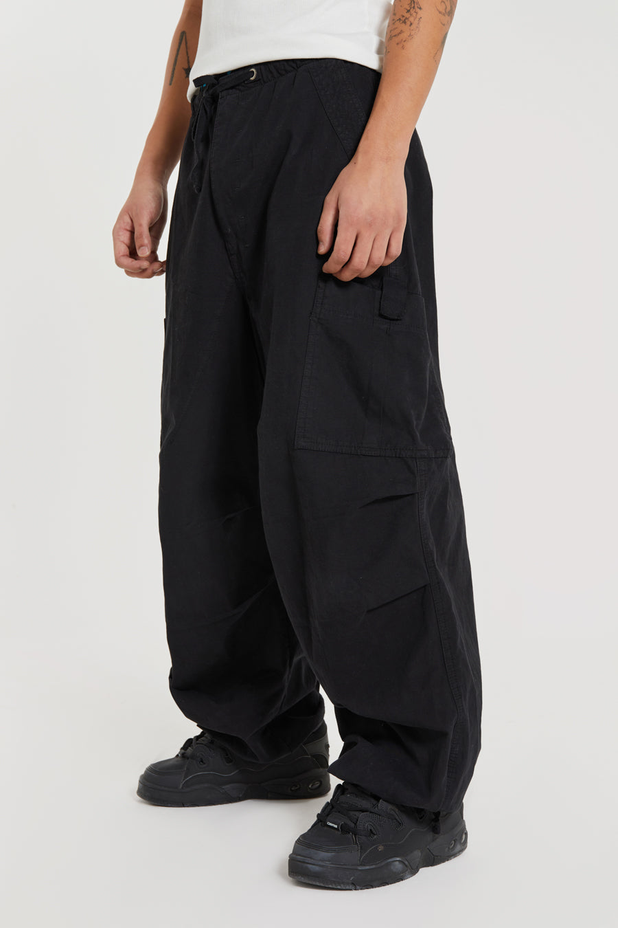 Unisex black oversized fitted parachute style cargo trousers with six pocket styling. 