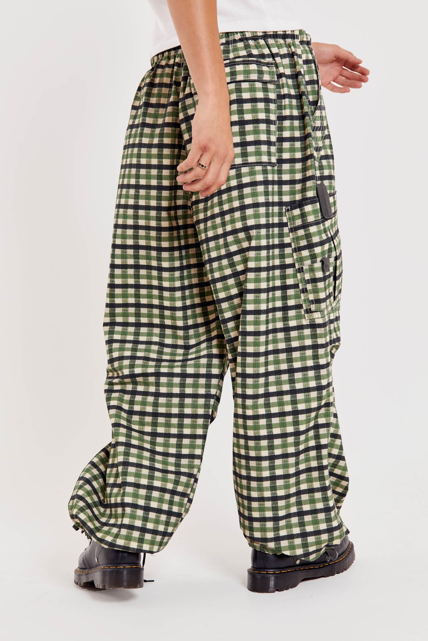 Male wearing green gingham printed check military style oversized cargo pants. 