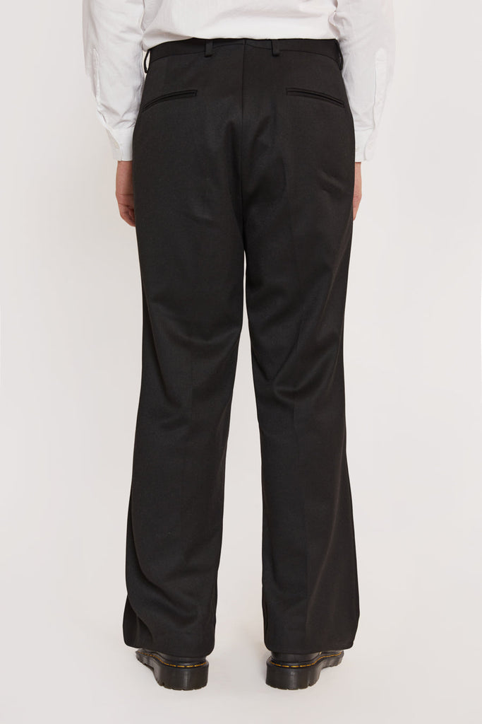 Male model wearing black flared suit pants. 