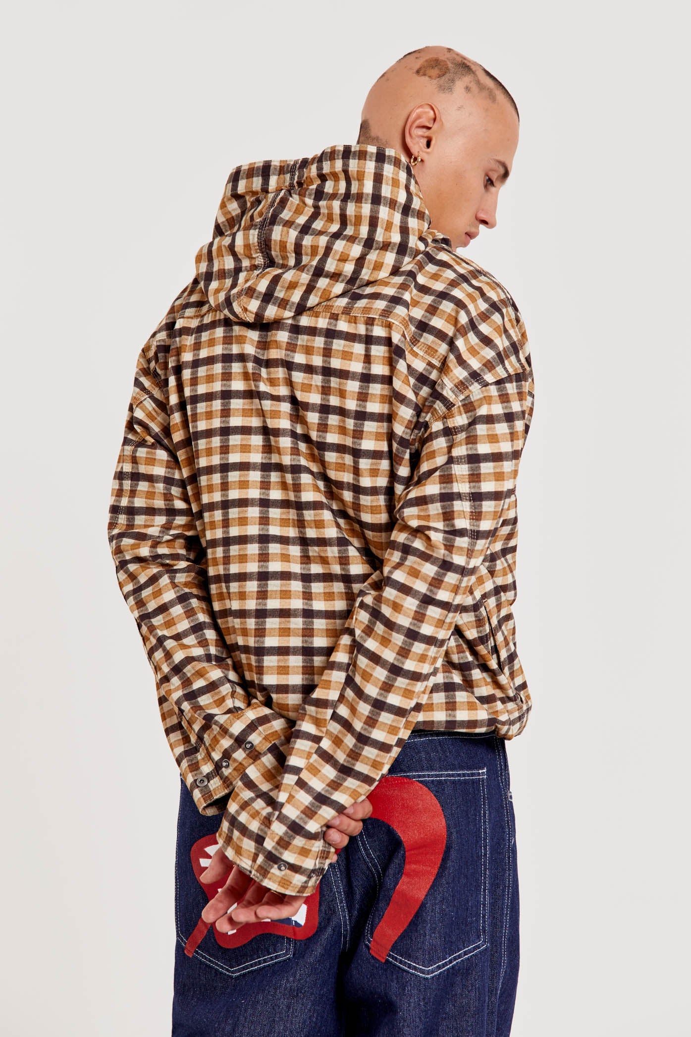 Male wearing brown gingham printed check long sleeved pullover jacket. 