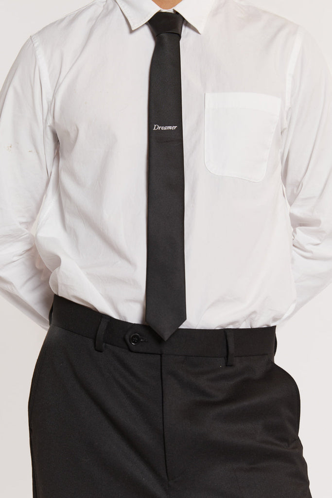 Male model wearing black flared suit pants. 