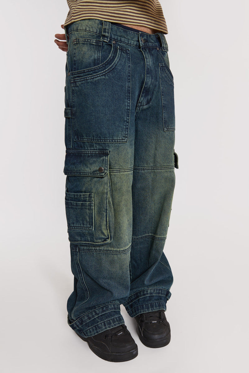 Male model wearing Sandblast Blue Denim Cargo Jeans. 