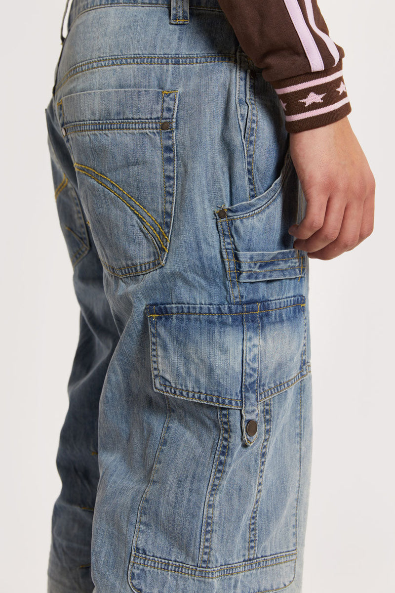 Male model wearing Light Wash Millennium Cargo Jeans. 