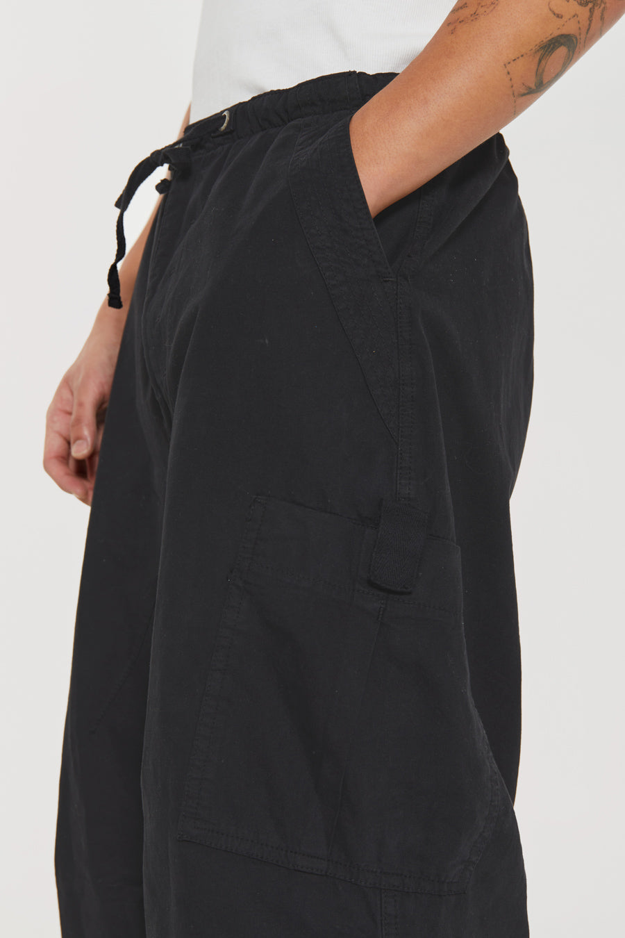 Unisex black oversized fitted parachute style cargo trousers with six pocket styling. 