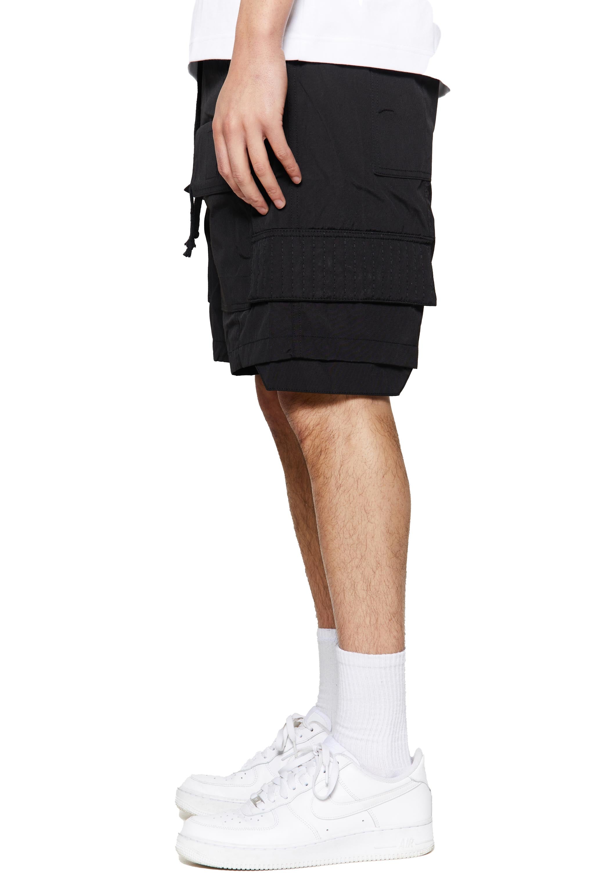 Black oversized cargo shorts in relaxed fit with ten pocket styling detail. 