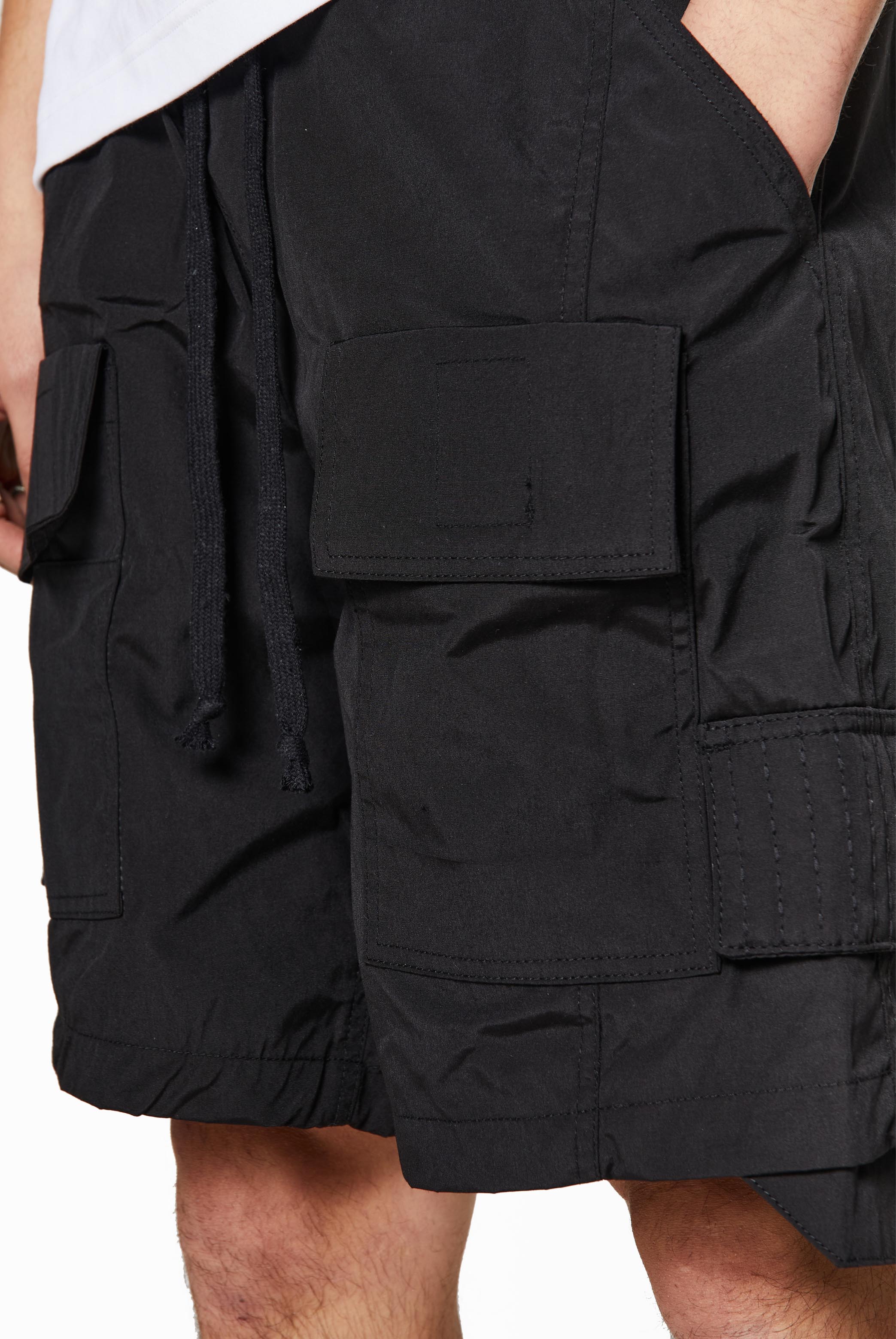 Black oversized cargo shorts in relaxed fit with ten pocket styling detail. 