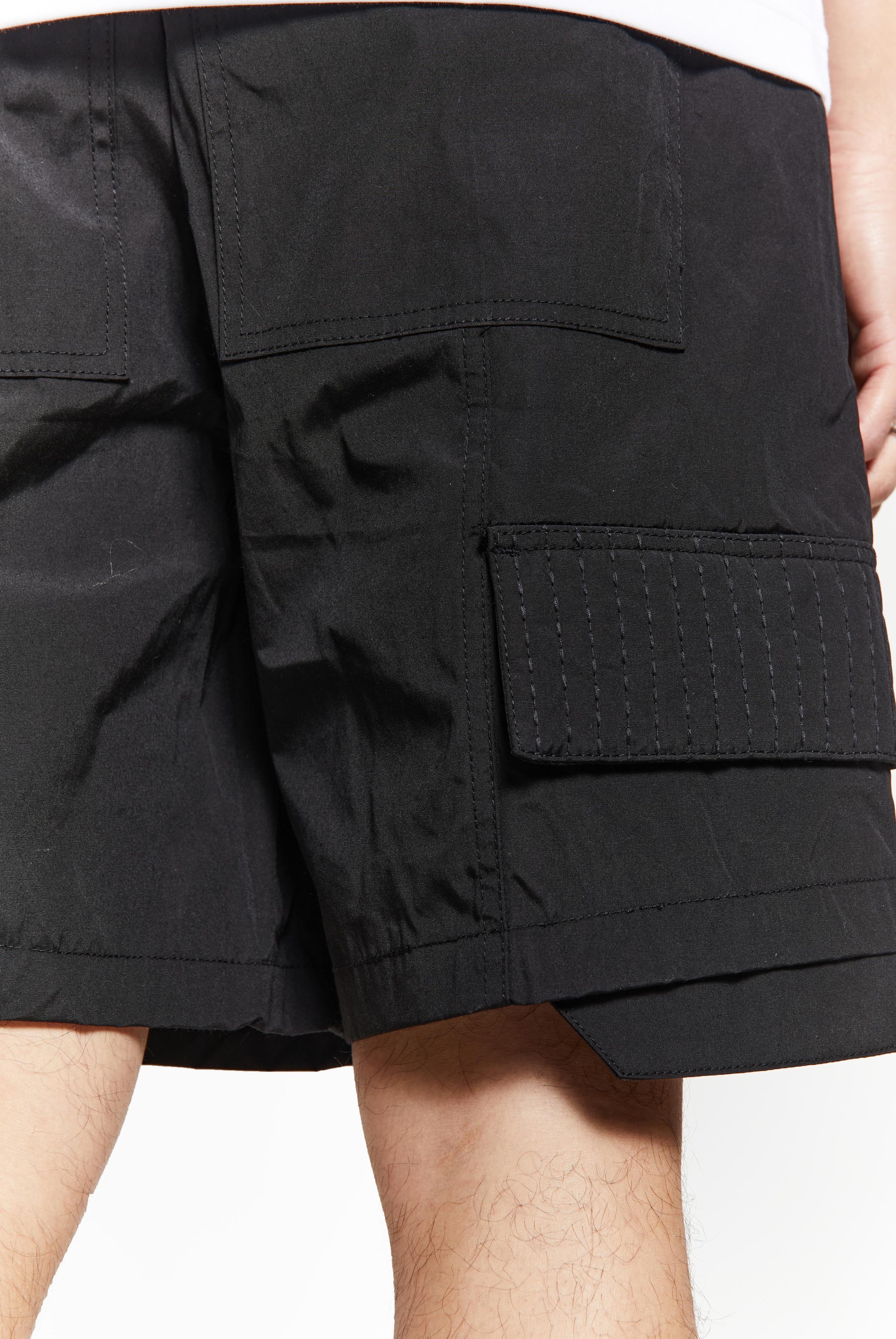 Black oversized cargo shorts in relaxed fit with ten pocket styling detail. 