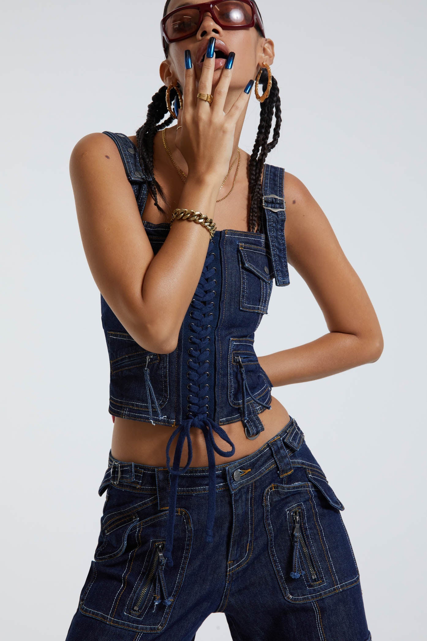 Female wearing indigo blue denim cargo style lace up corset top. Styled with the matching denim cargo trousers.  