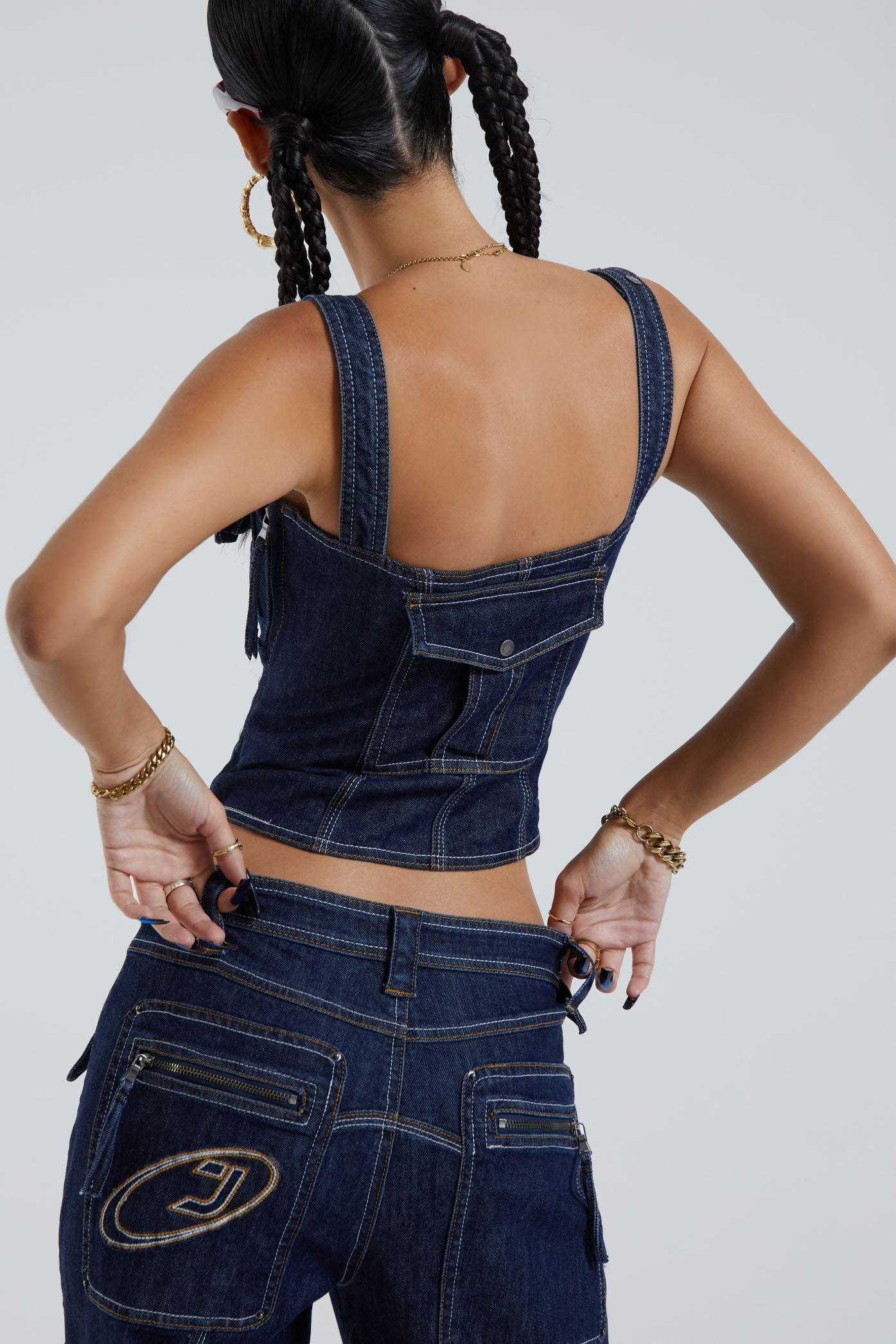 Female wearing indigo blue denim cargo style lace up corset top. Styled with the matching denim cargo trousers.  