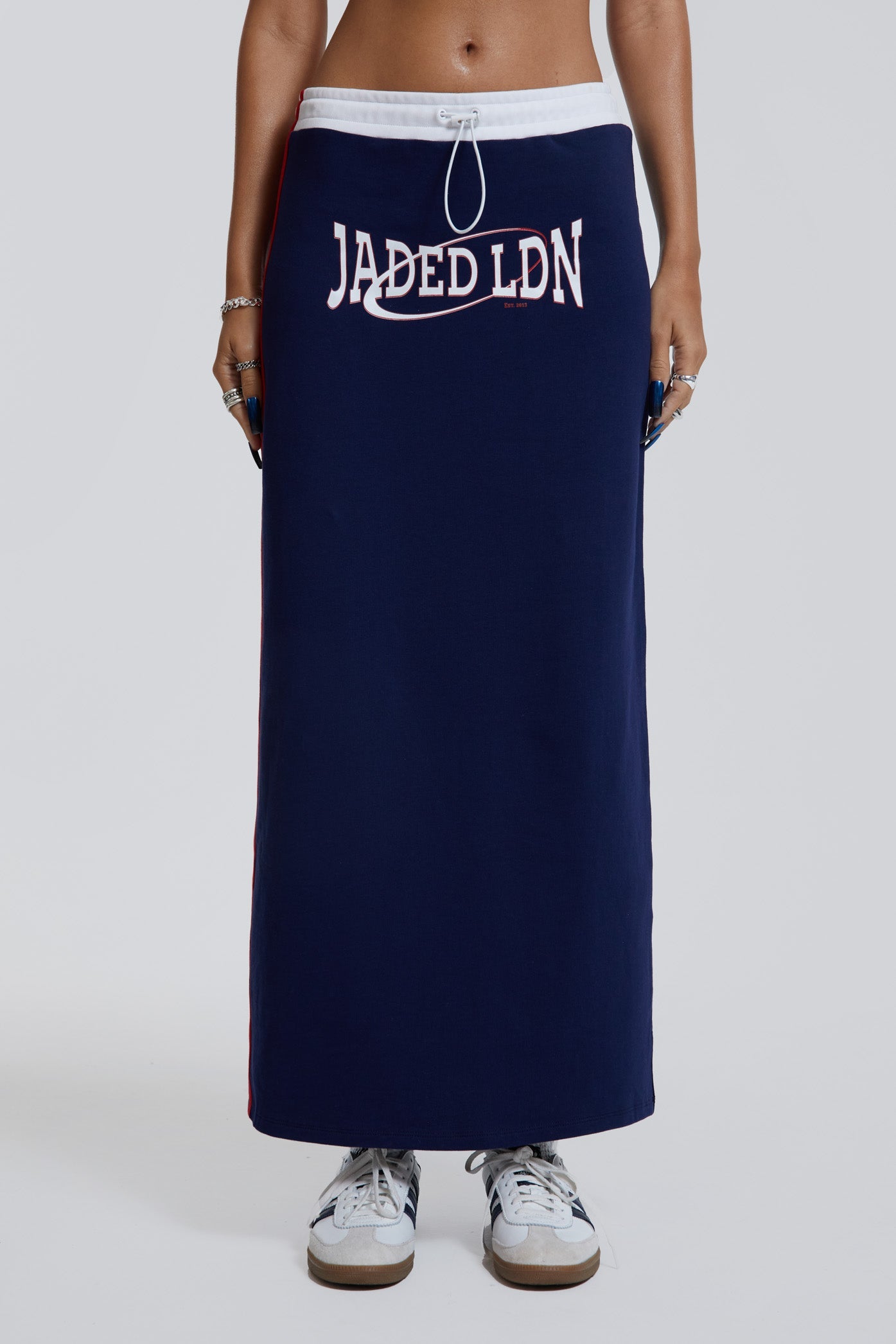 Female wearing navy sporty midi length skirt with toggle waistband detail. 