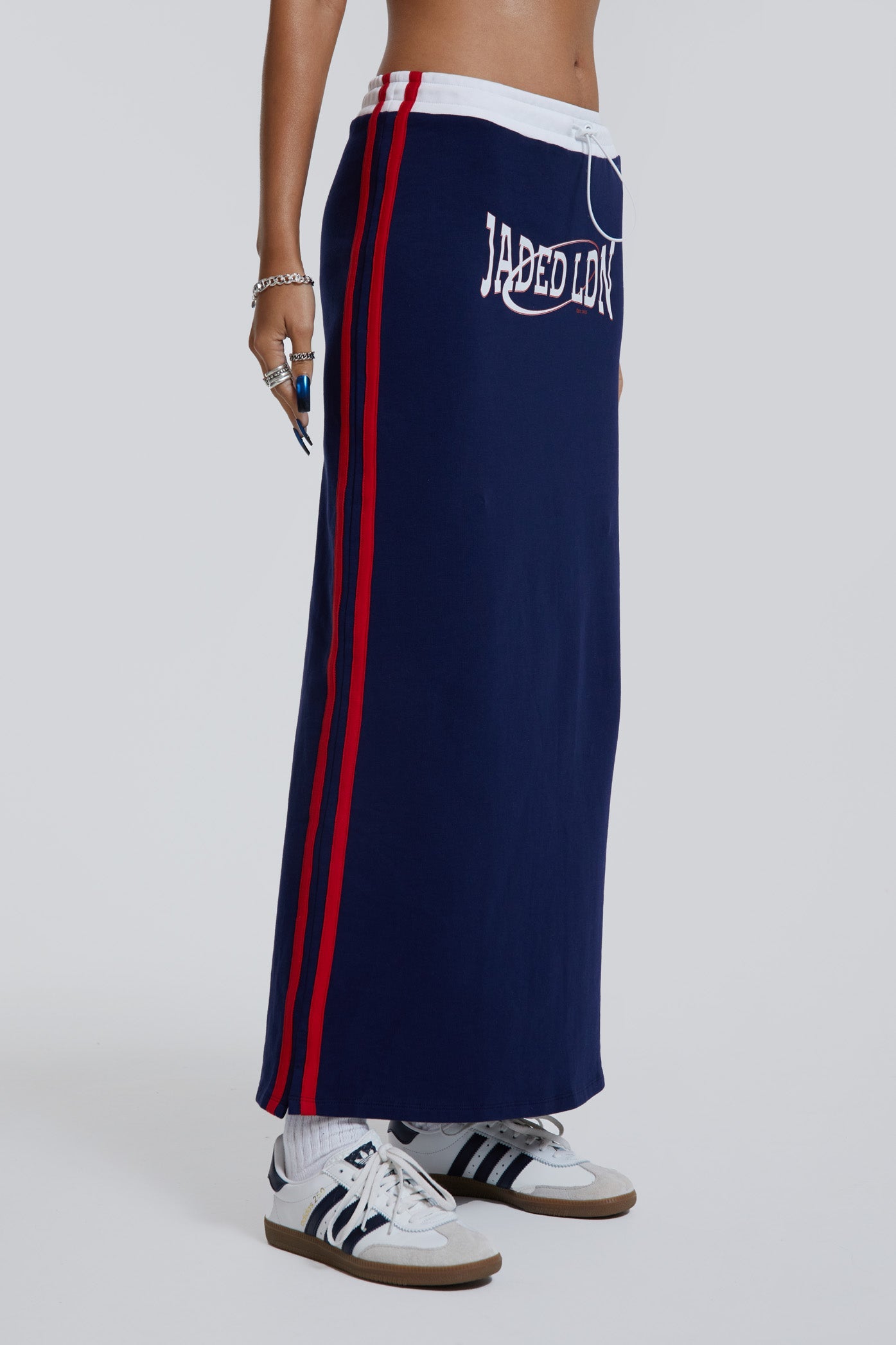 Female wearing navy sporty midi length skirt with toggle waistband detail. 