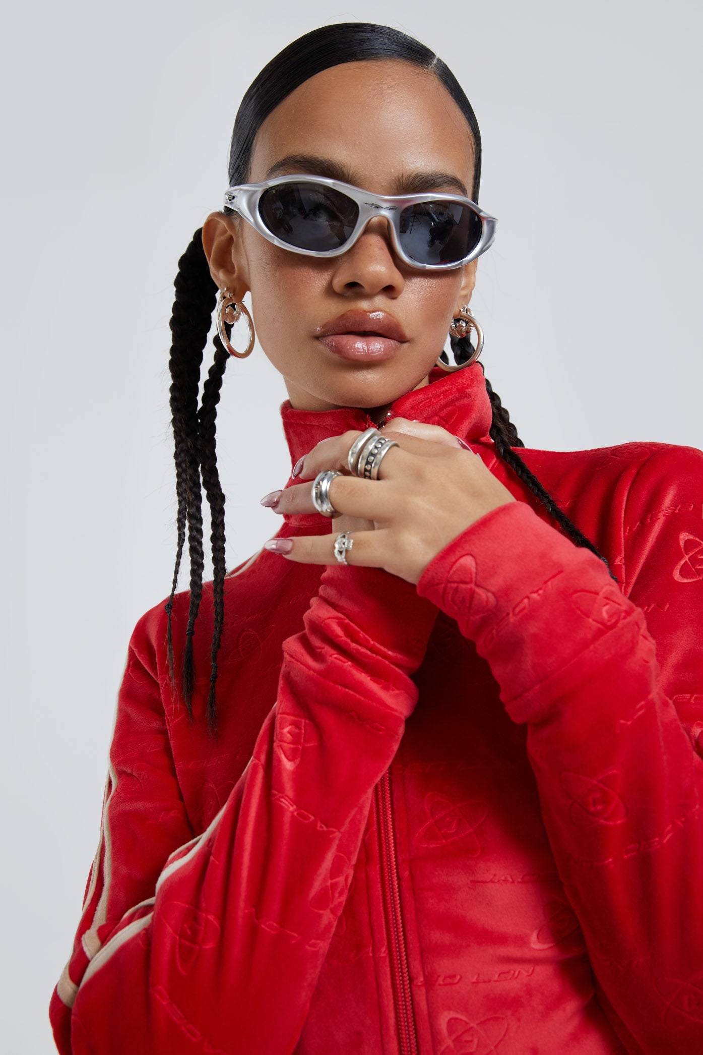 Female wearing red logo monogram embossed high neck long sleeve velour track top. 