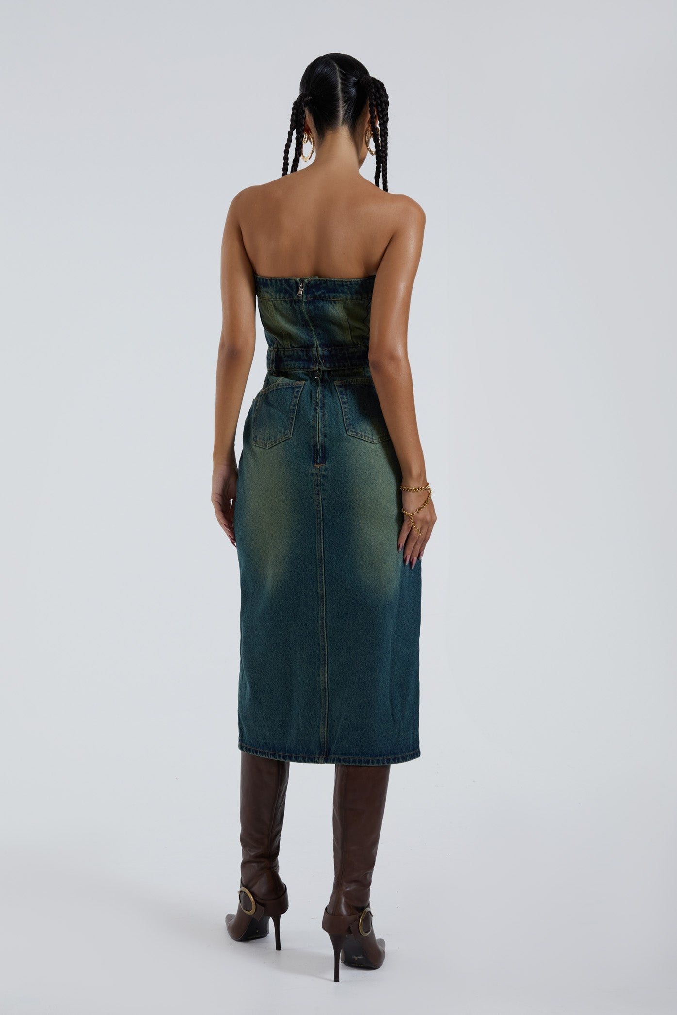 Female wearing blue bandeau denim corset maxi length dress with front split detail. 