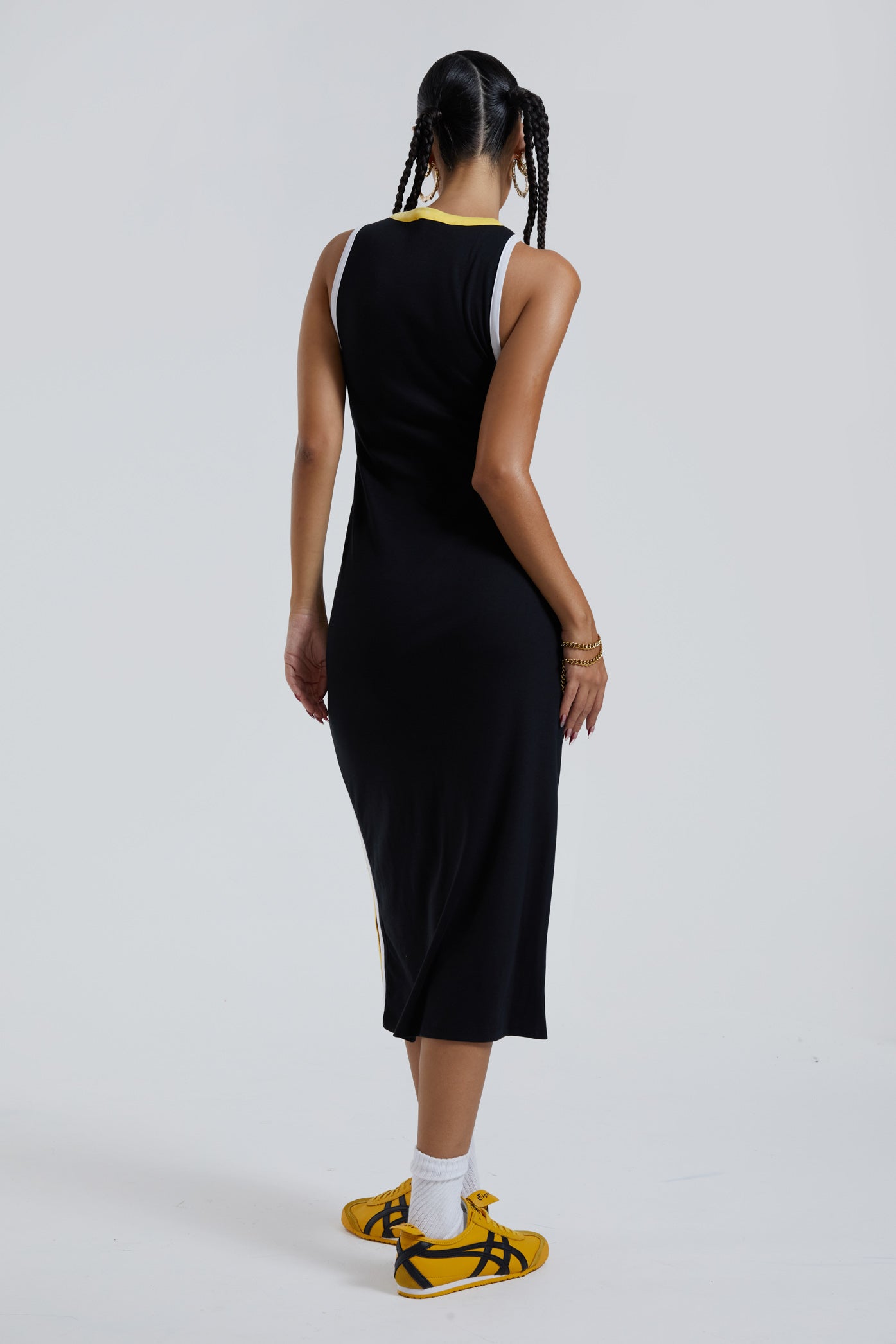  Female wearing black sporty style zip up front maxi length dress with side stripe detail. 