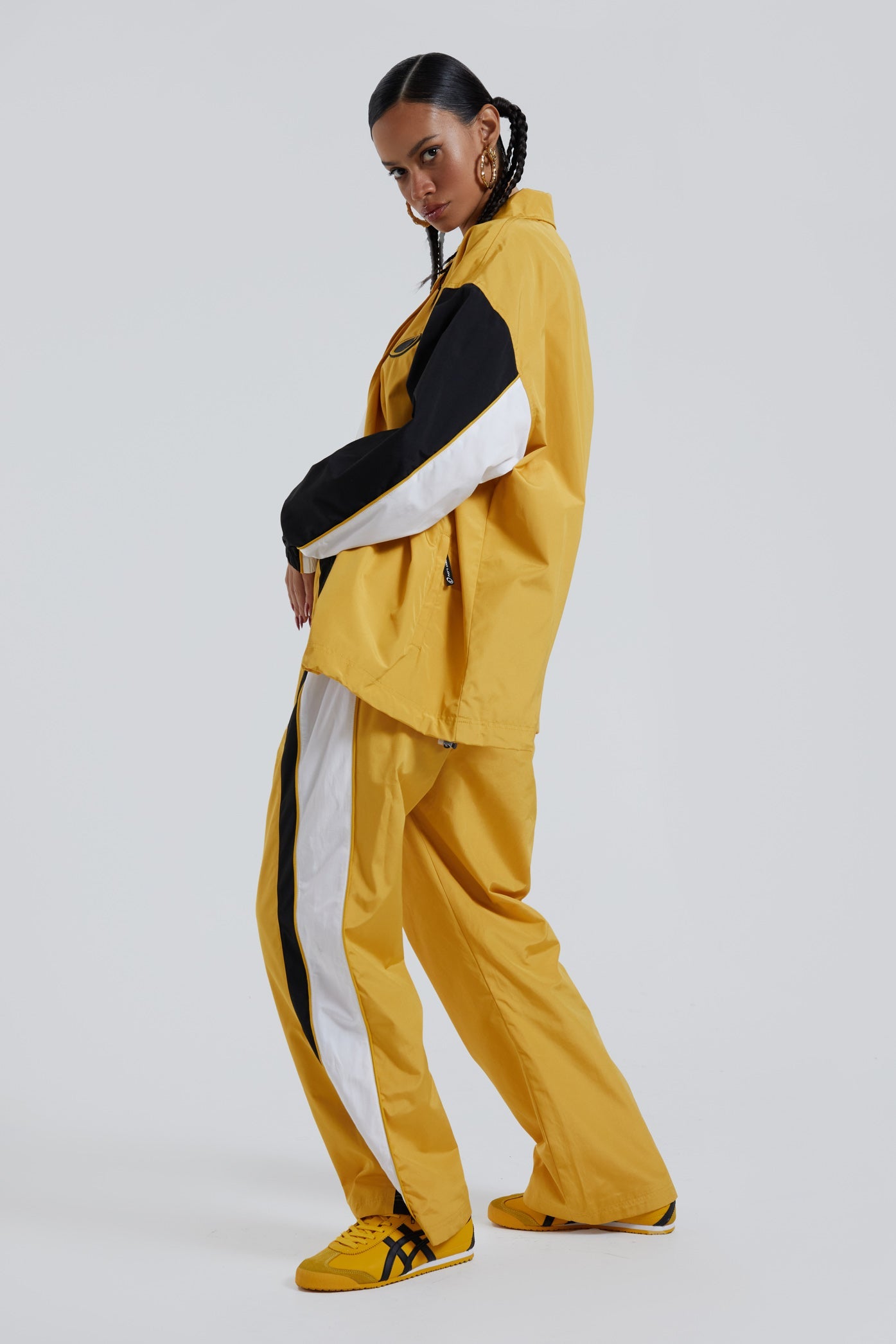 Female wearing yellow oversized track jacket with Jaded branding detail. Styled with the matching track pants. 