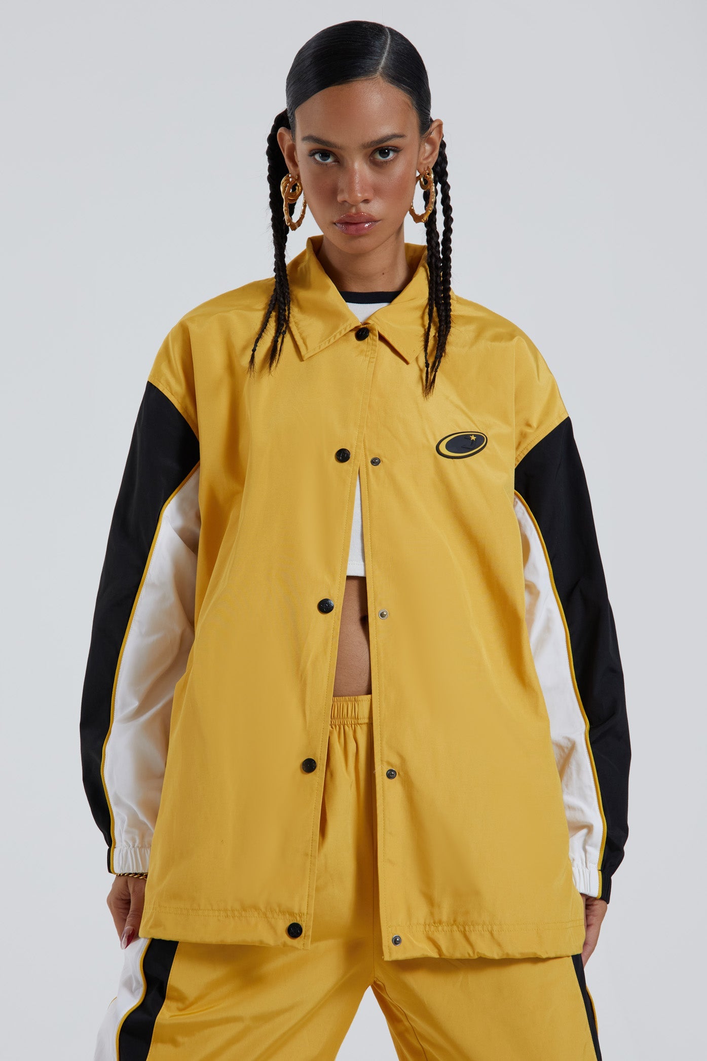 Female wearing yellow oversized track jacket with Jaded branding detail. Styled with the matching track pants. 