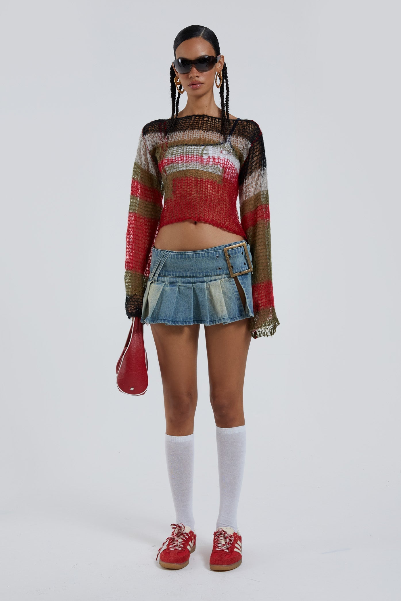 Female wearing multicoloured abstract fine knit long sleeve cropped jumper. Styled with the blue pleated denim mini skirt. 