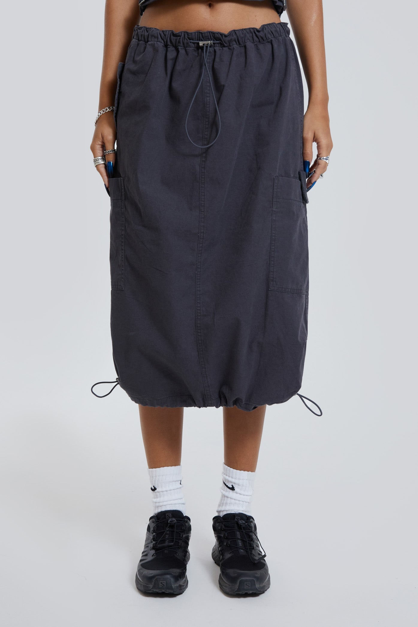 Female wearing grey cargo parachute style maxi skirt. 