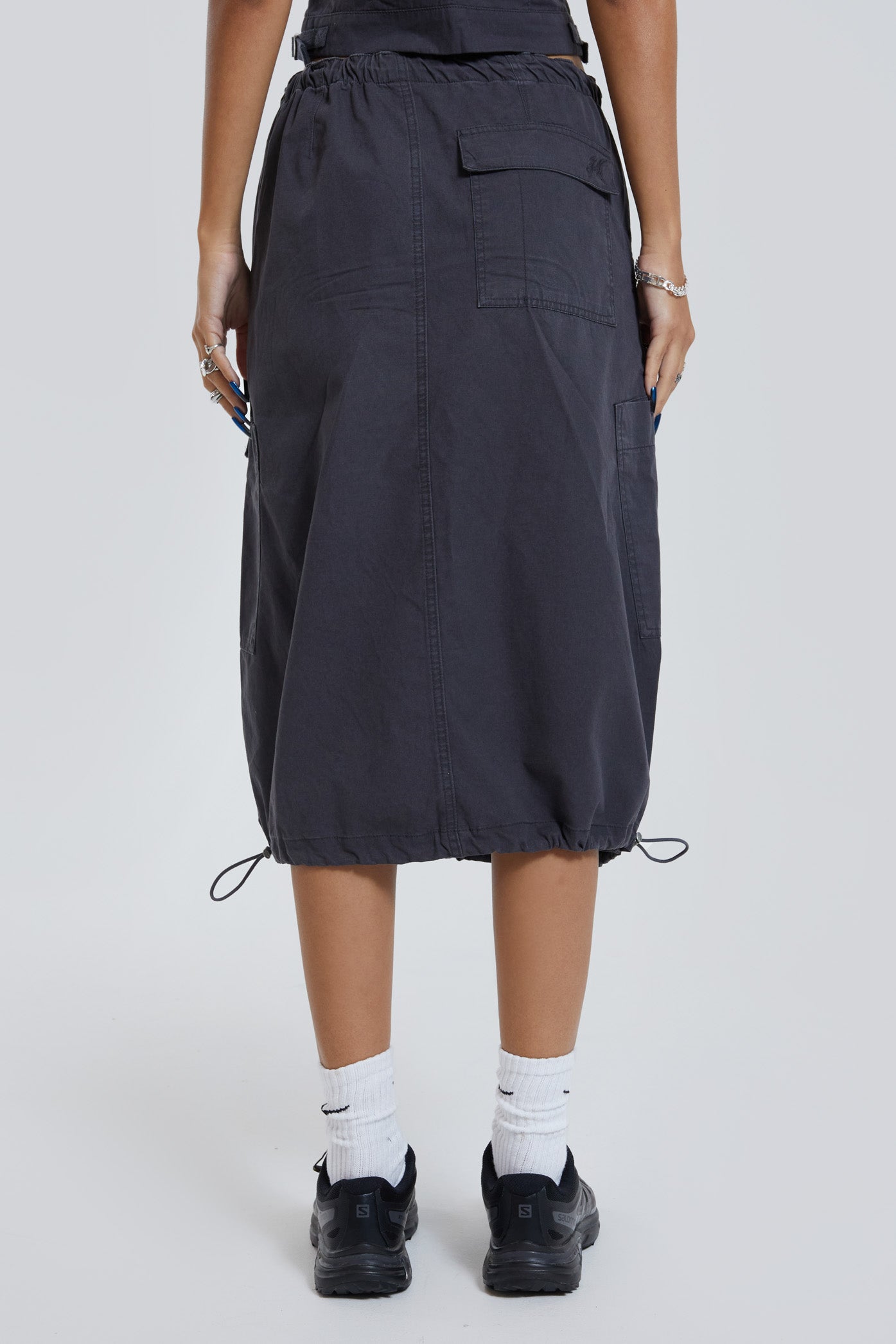 Female wearing grey cargo parachute style maxi skirt. 