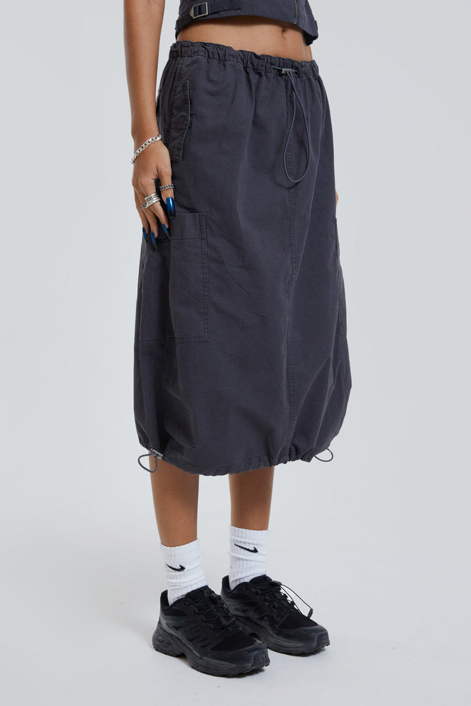 Female wearing grey cargo parachute style maxi skirt. 