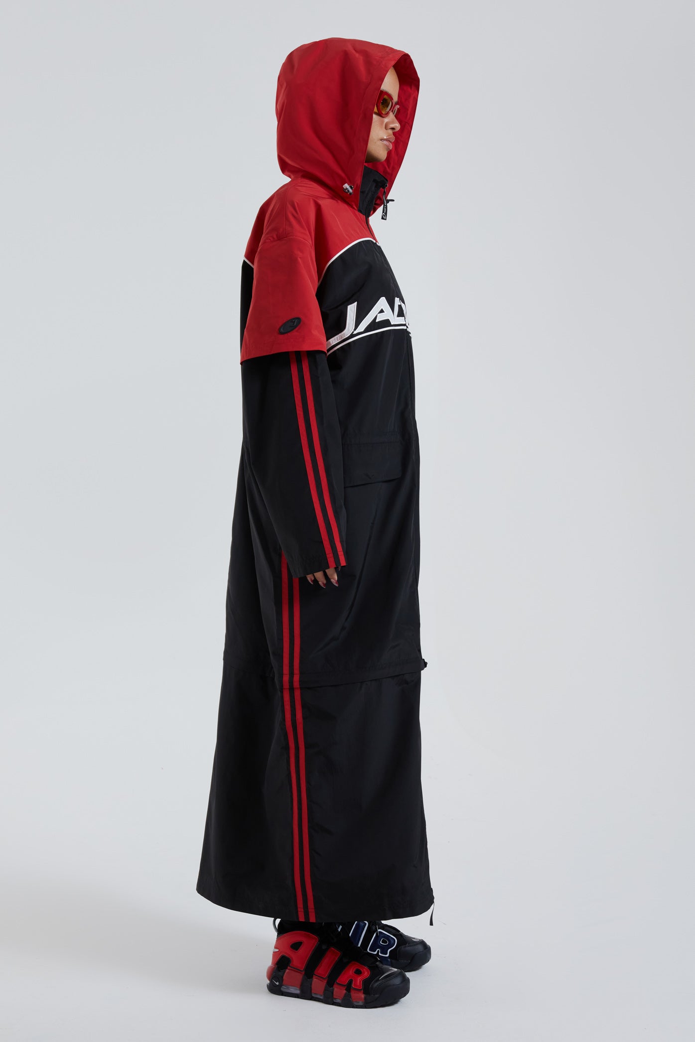 Female wearing red & black maxi length long sleeve sporty cagoule coat.