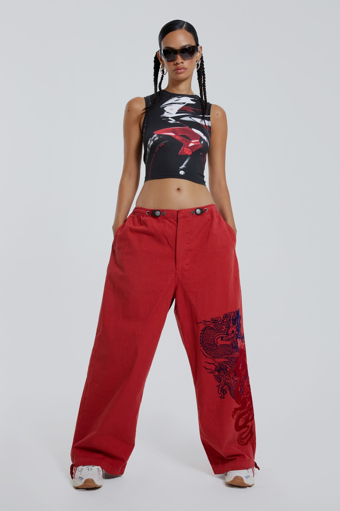 Female wearing red military cargo parachute pants with black dragon flock print. 