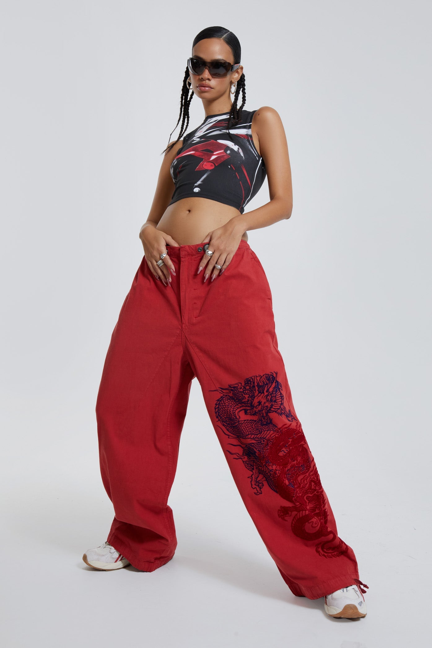 Female wearing red military cargo parachute pants with black dragon flock print. 