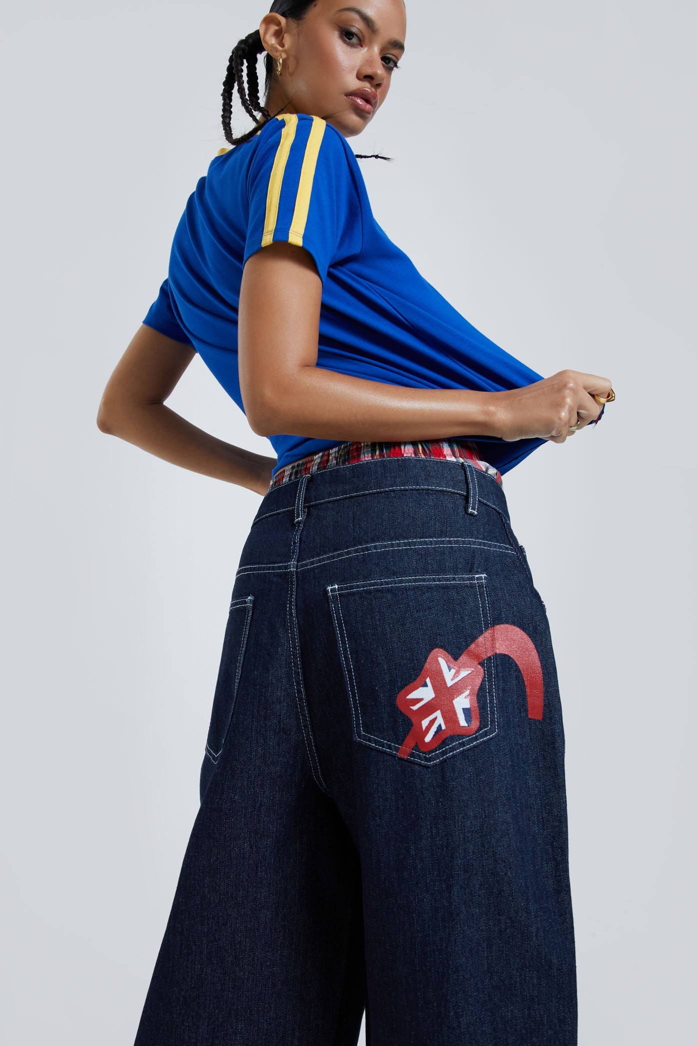 Female wearing blue baby style t-shirt with embroidered detail. Styled with oversized blue denim jorts. 