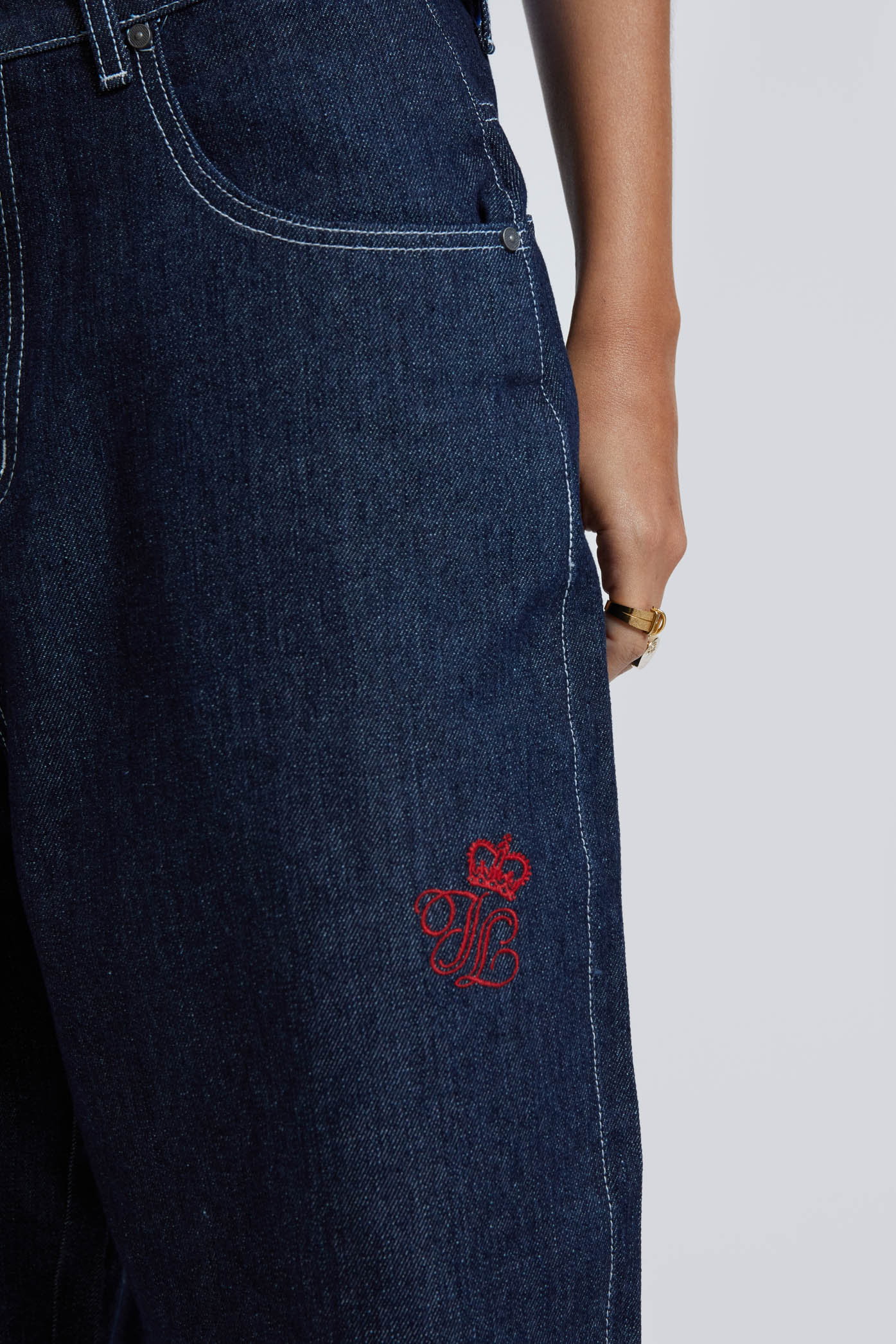 Female wearing sandblast washed denim oversized jorts in a jumbo fit with embroidered pocket patch detail. 