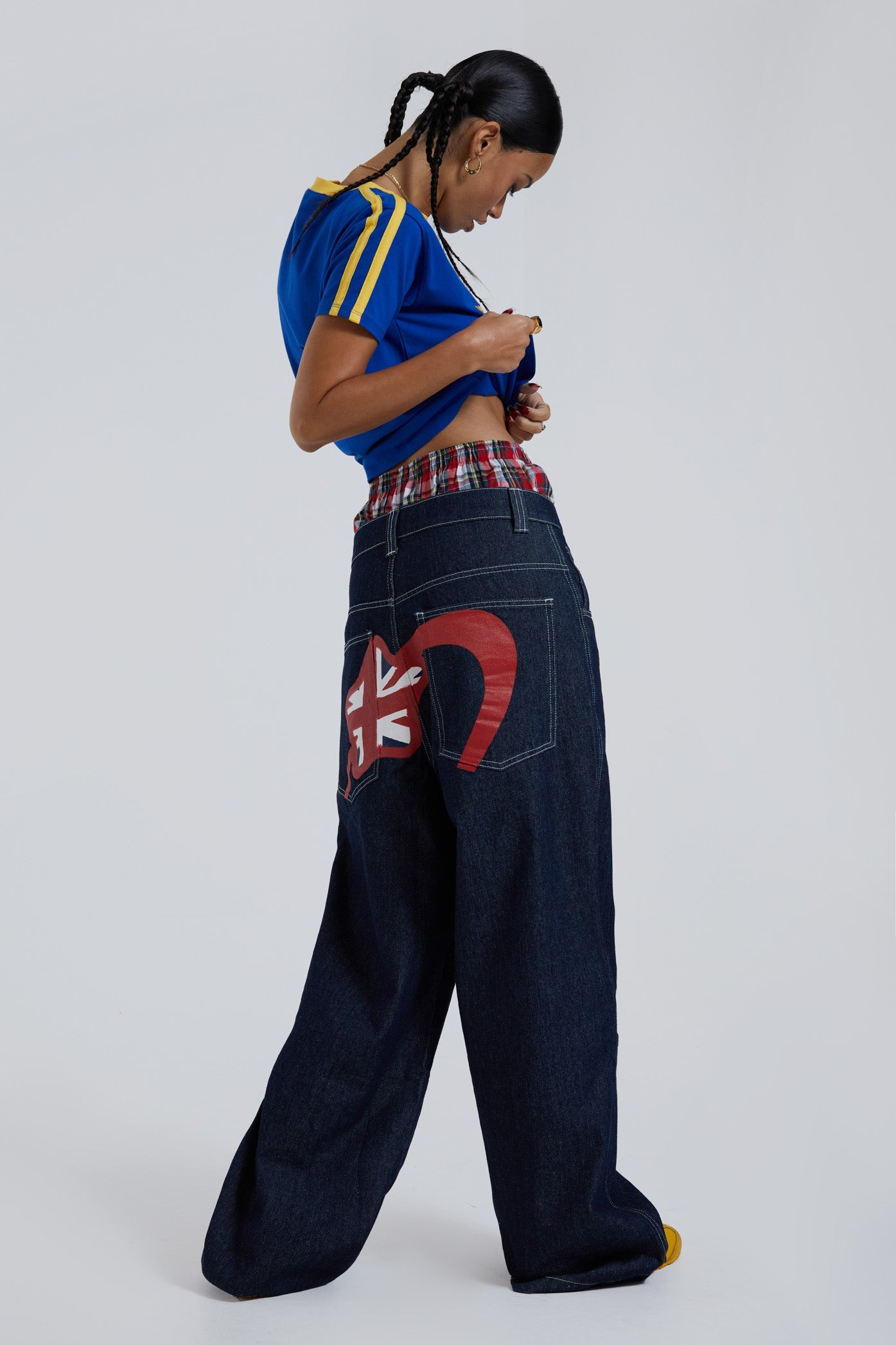 Female wearing sandblast washed denim jeans in an oversized skate fit with embroidered coin pocket and Union Jack artwork across back body and pockets. 