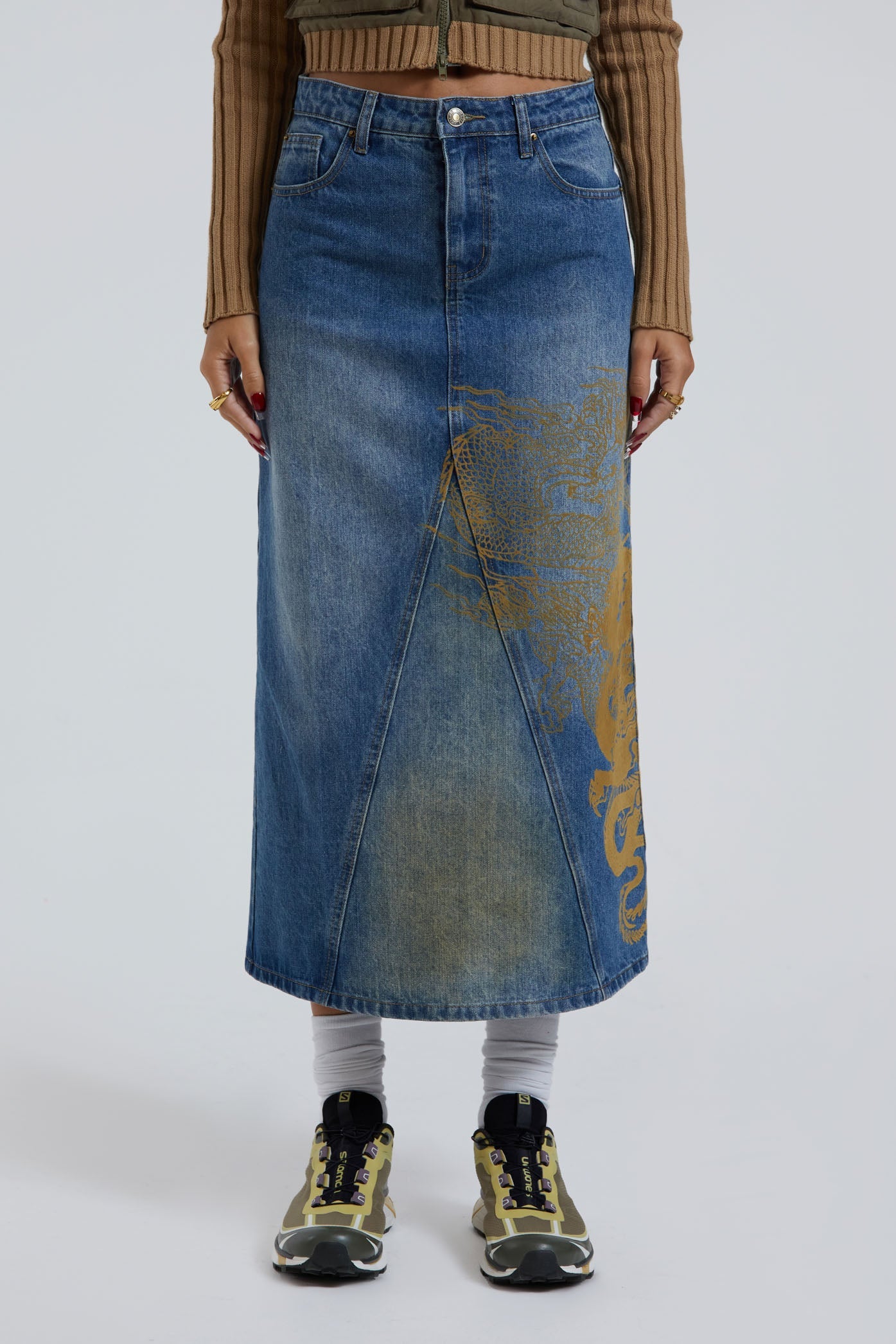 Female wearing sandblast washed denim 00's style maxi skirt with dragon flock print. 