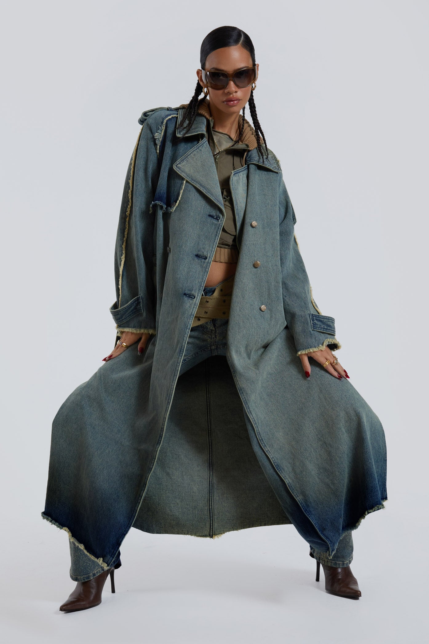 Female wearing blue denim trench style long sleeve parka coat with detachable belt detail. 