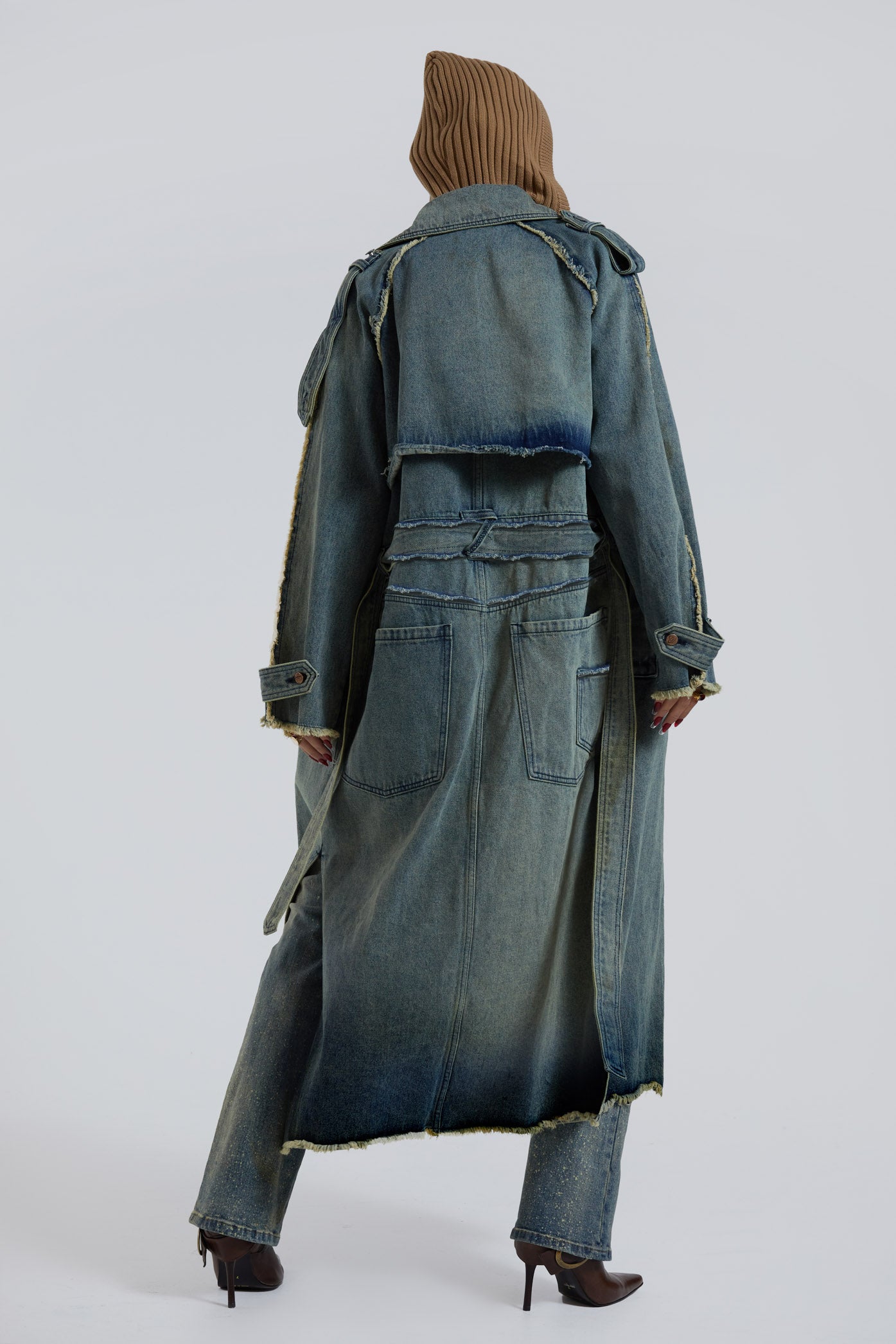 Female wearing blue denim trench style long sleeve parka coat with detachable belt detail. 