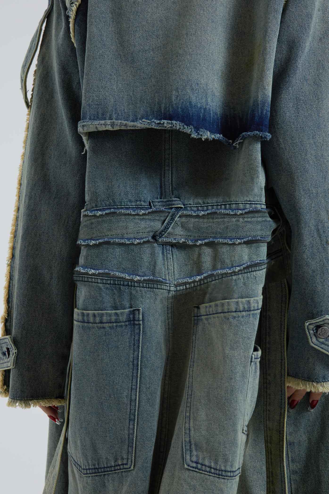 Female wearing blue denim trench style long sleeve parka coat with detachable belt detail. 