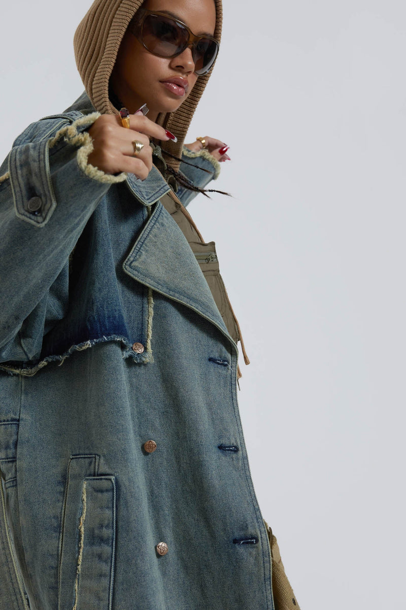 Female wearing blue denim trench style long sleeve parka coat with detachable belt detail. 