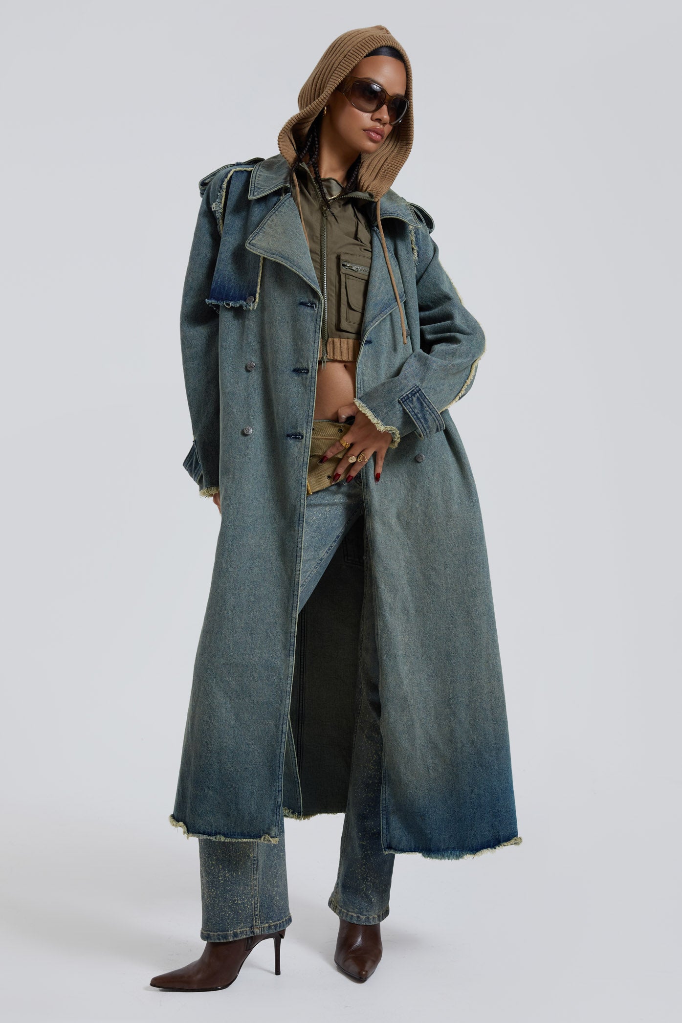 Female wearing blue denim trench style long sleeve parka coat with detachable belt detail. 