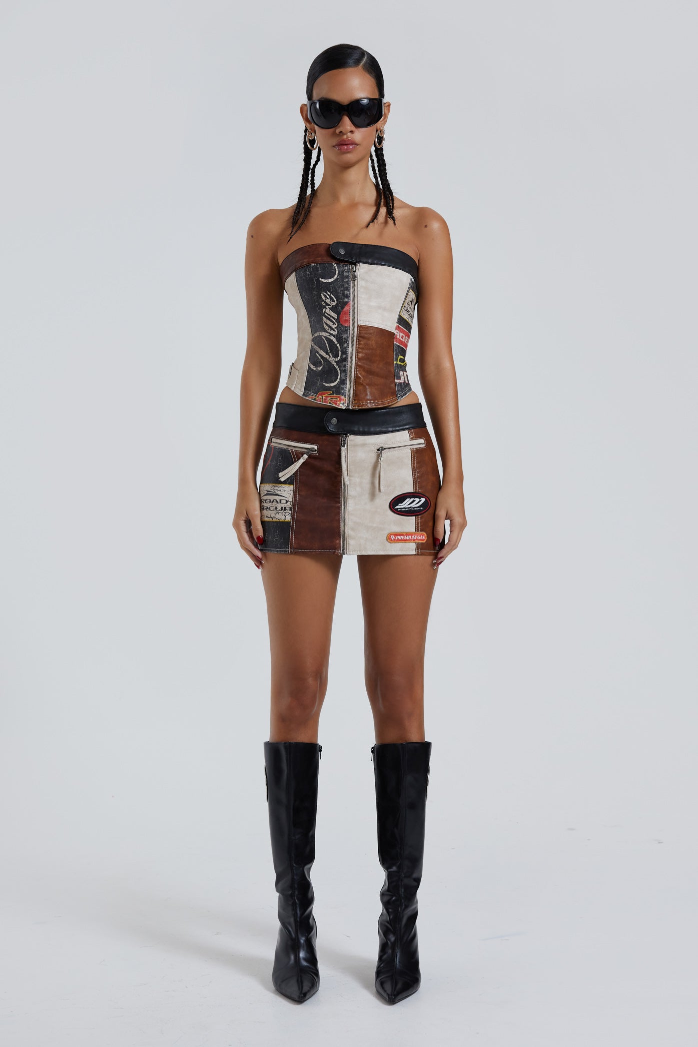 Female wearing moto PU panelled corset style bandeau top with dipped hem detail. Styled with the matching mini skirt.  