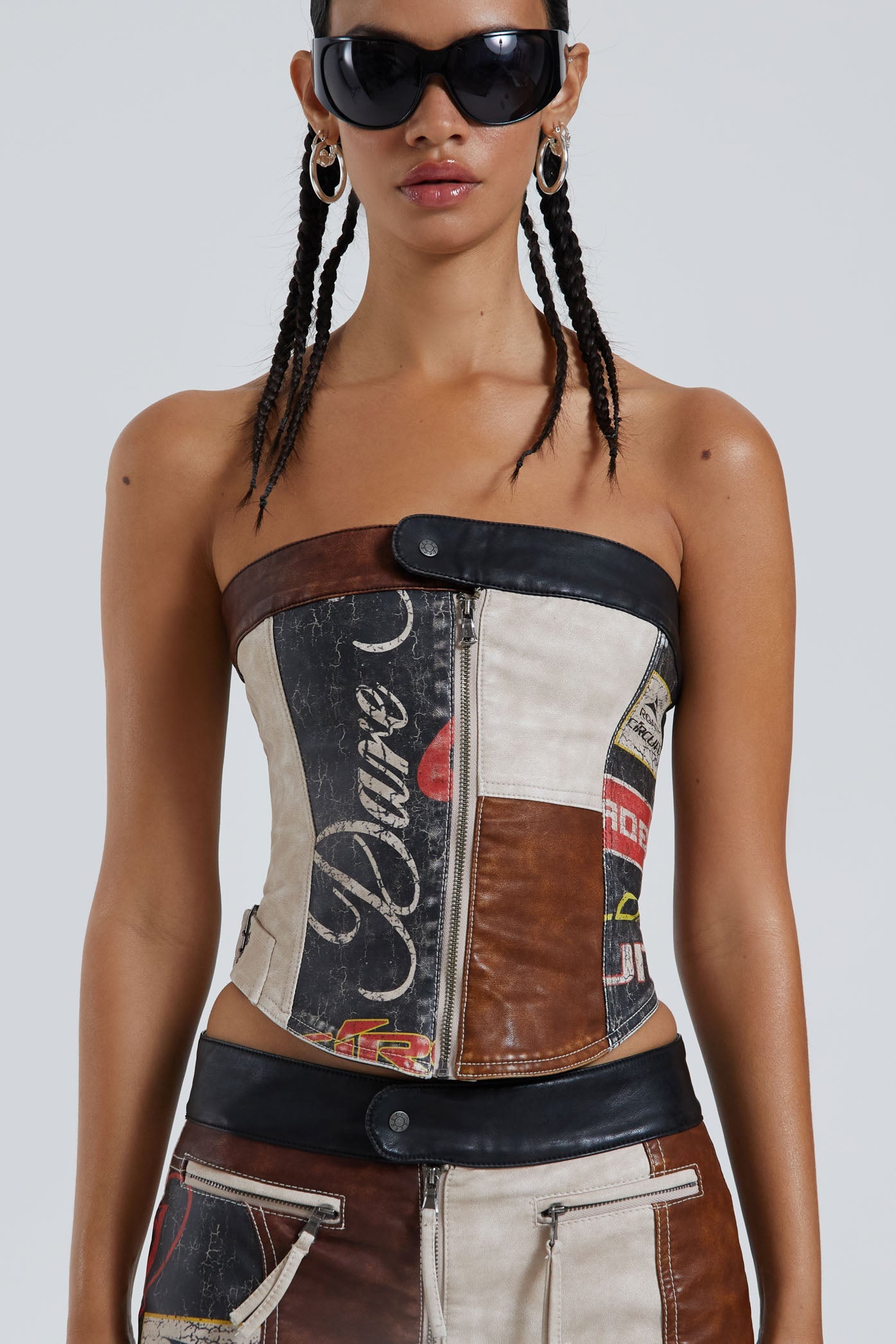 Female wearing moto PU panelled corset style bandeau top with dipped hem detail. Styled with the matching mini skirt.  