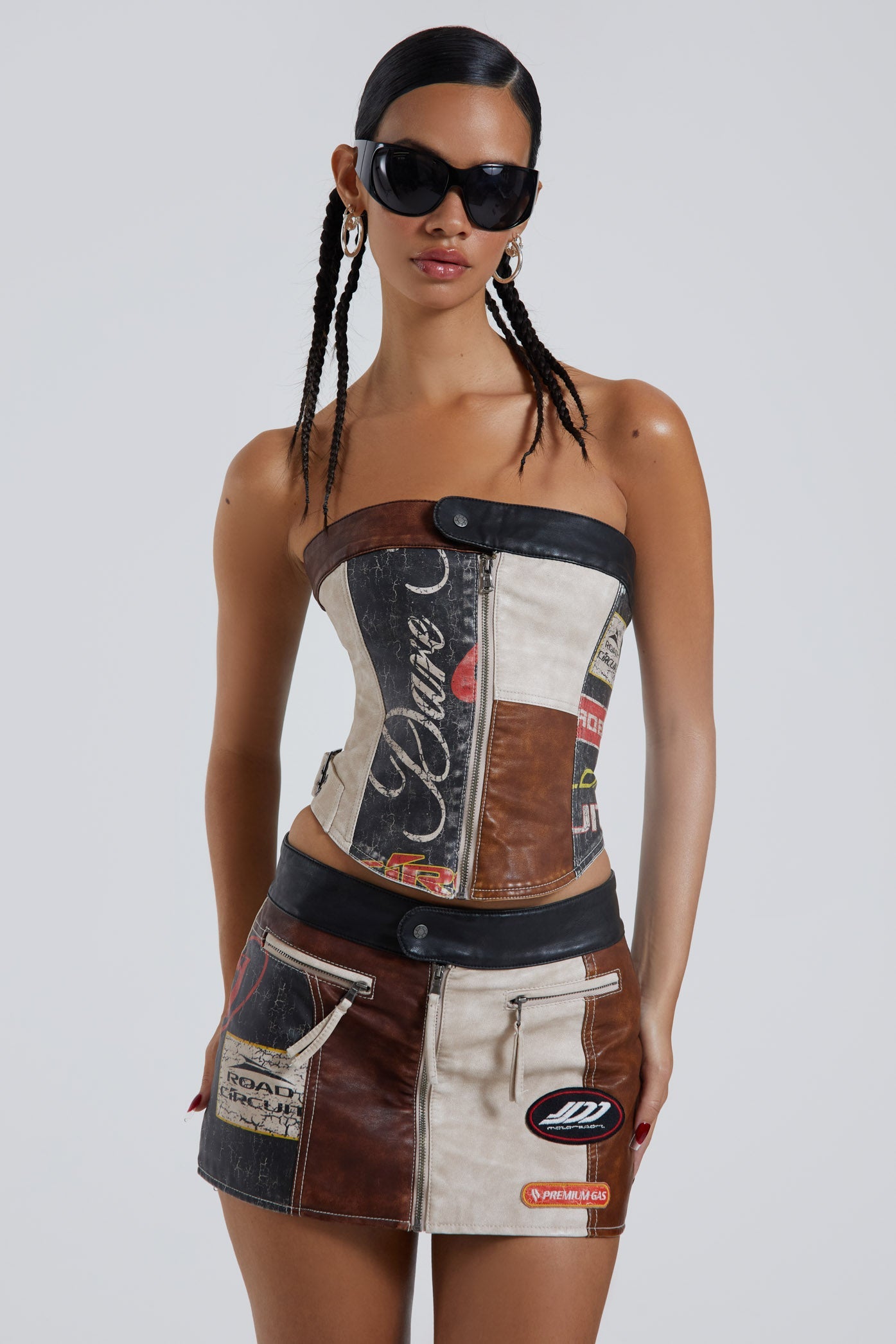 Female wearing moto PU panelled corset style bandeau top with dipped hem detail. Styled with the matching mini skirt.  