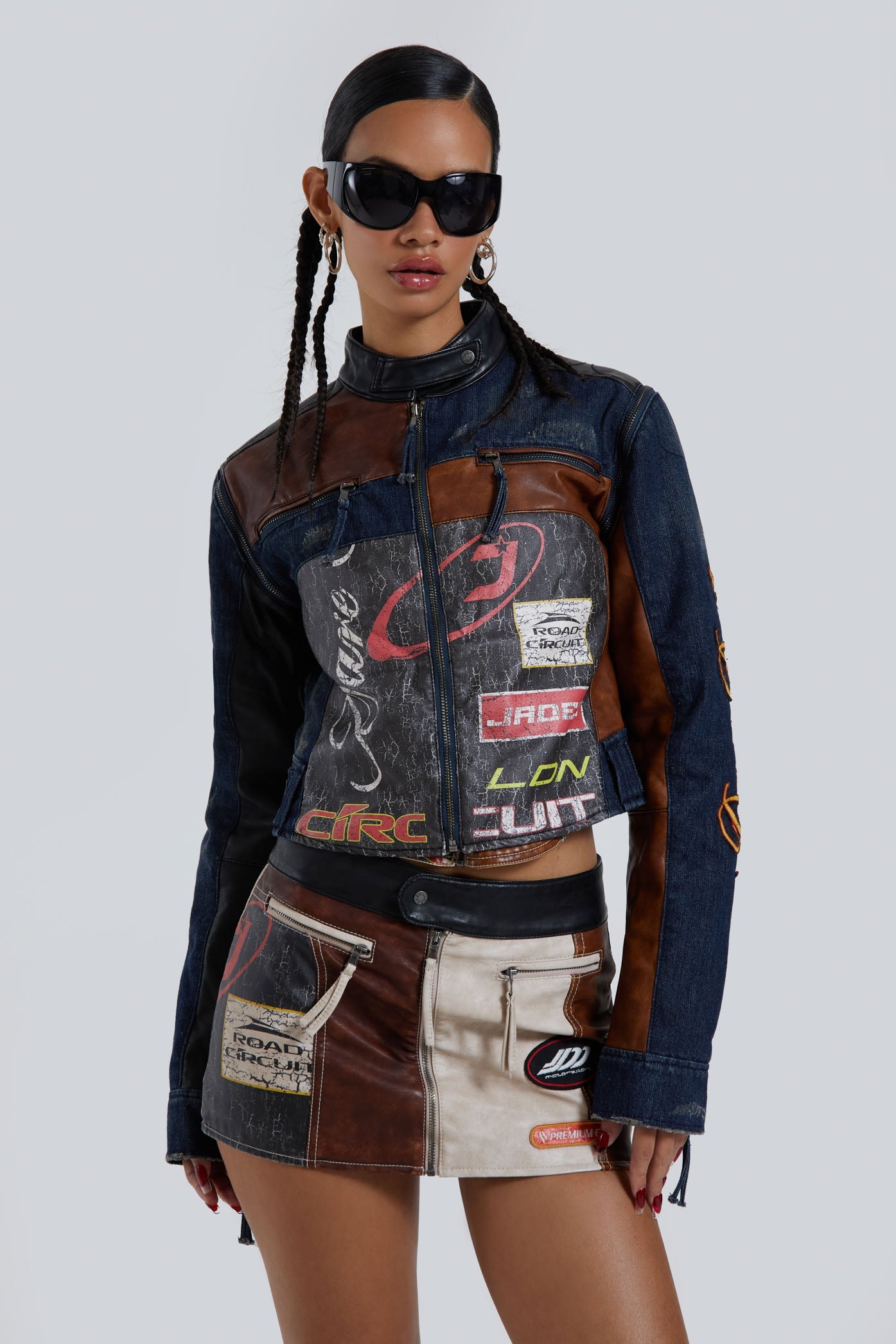 Female wearing denim PU zip up long sleeve moto jacket with embroidery detail. Styled with the matching motto mini skirt. 