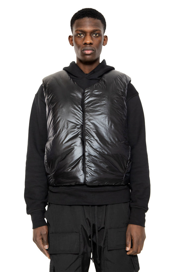 Black nylon puffer sleeveless gilet styled with a black hoodie and black trousers. 