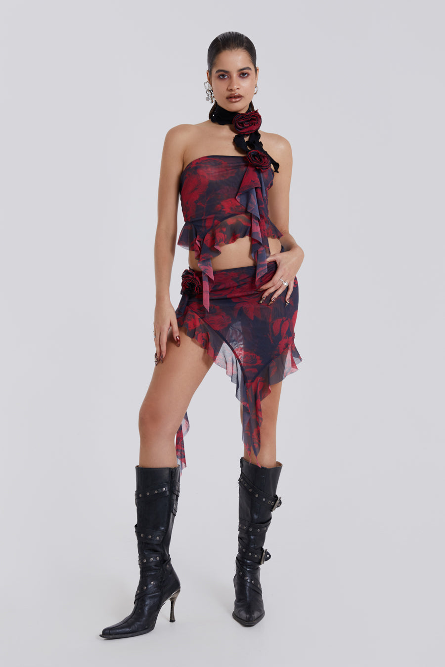 Female model wearing Dark Rose Print Asymmetric Bandeau Top. Styled with the matching asymmetric mini skirt and neck tie. 