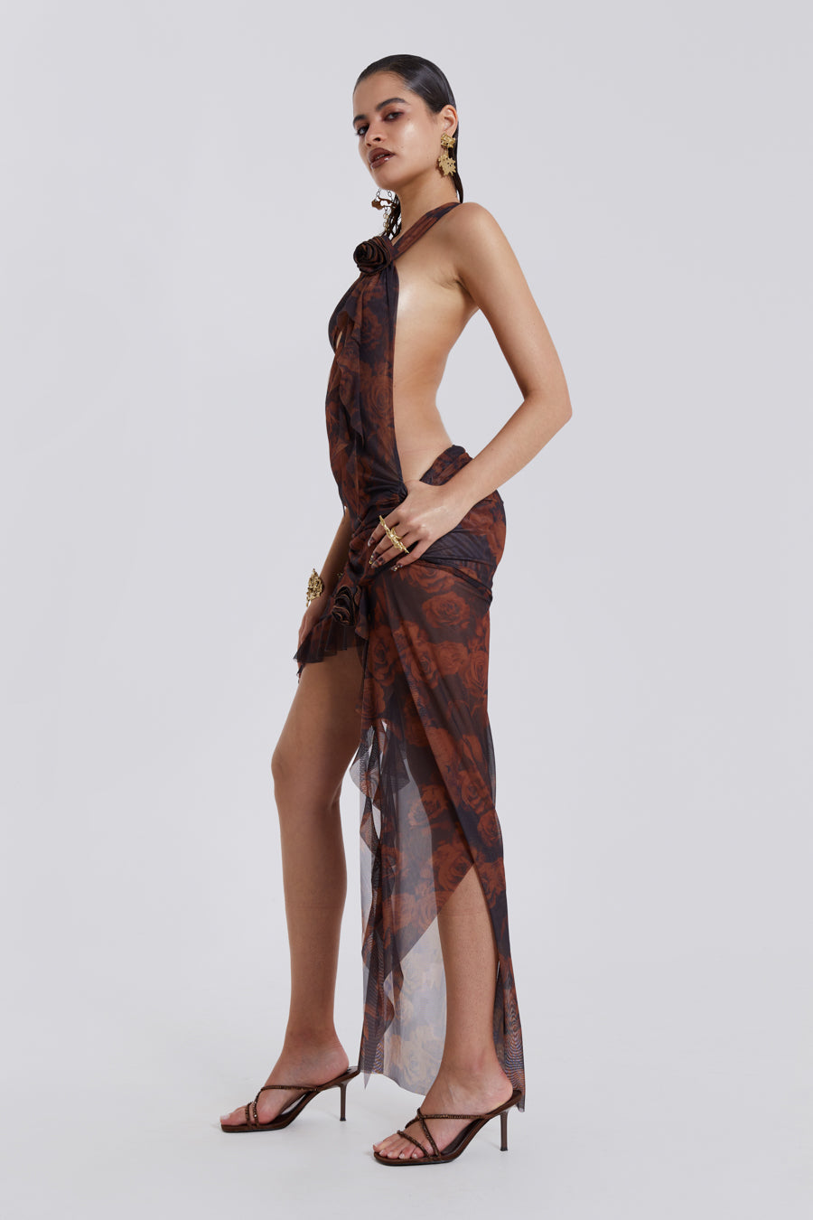 Photo of model wearing Grunge Rose Print One Shoulder Draped Rosette Maxi Dress with cut out detail. Styled with heels. 