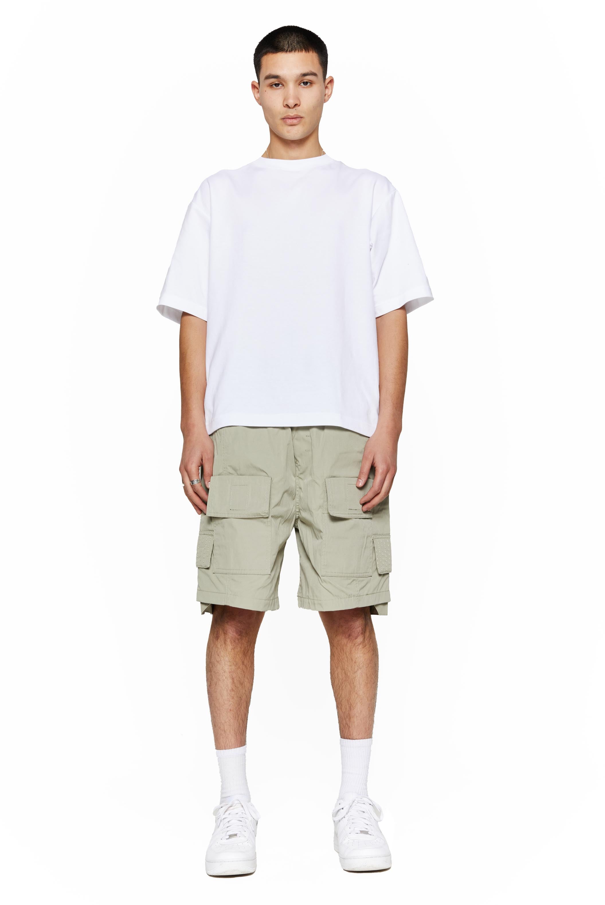 Green oversized cargo shorts in relaxed fit with ten pocket styling detail. 